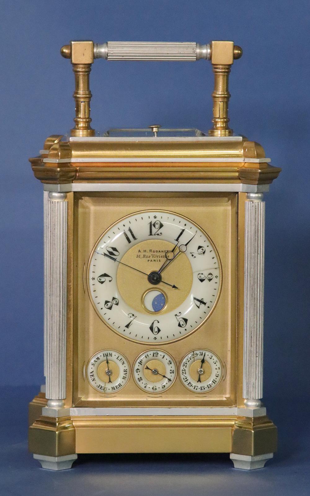 A.H.Rodanet, Paris

The silvered and gilt-bronze case has canted corners with reeded columns, a hinged handle and beveled glasses to 5 sides.
The dial has bone chapter rings with Arabic numbers for the hours, alarm and date, the days of the week