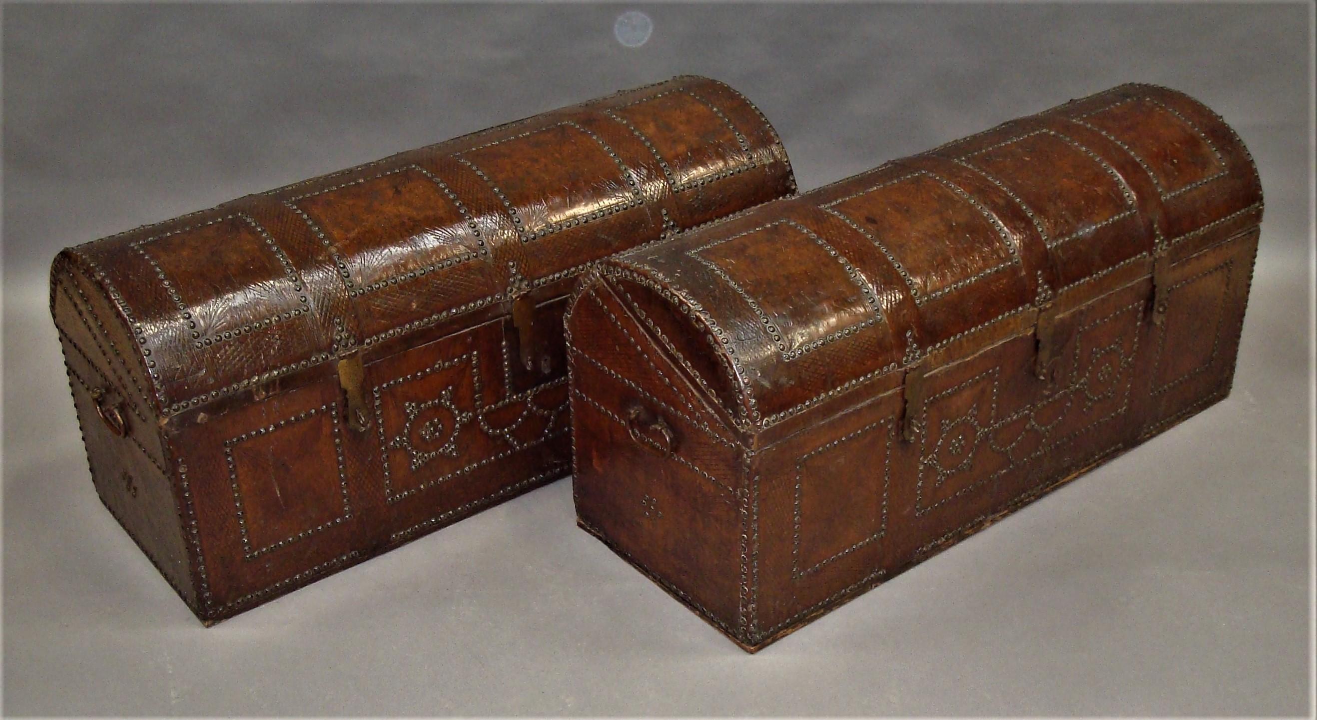 A rare 18th century pair of Spanish leather chest travelling trunks, in original tan brown leather with tooled decoration. The dome topped lids with four brass studded panels and three iron hasps to the front. The front with a geometric brass