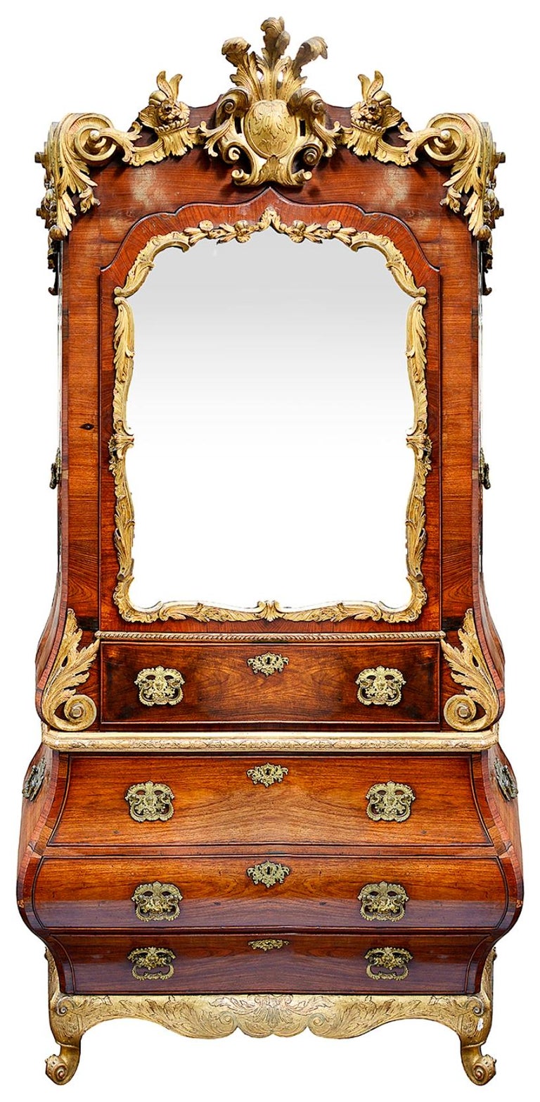 A very impressive 18th Century Rococo carved giltwood and Walnut bureau bookcase, having wonderful scrolling foliate and plume decoration to the cornice, a single mirror door with giltwood surround, opening to reveal shelves within, the top drawer