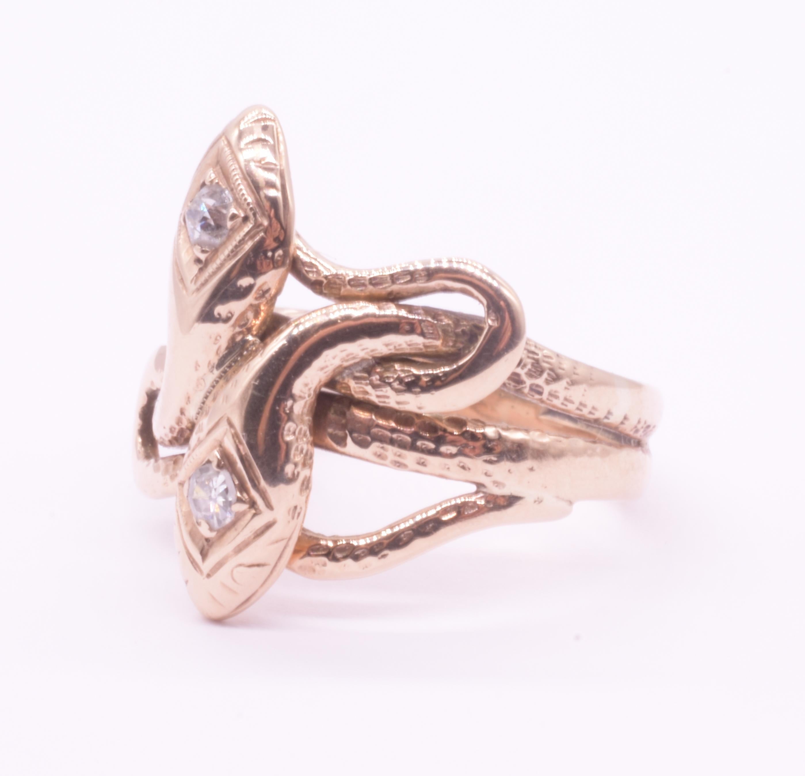 We love this 15K double snake ring cleverly set with two sparkling round diamond gemstones set securely in a carved bordered diamond shape on the snake's head. Note the curves on the intertwined snake, the intricate way the gold bands weave together