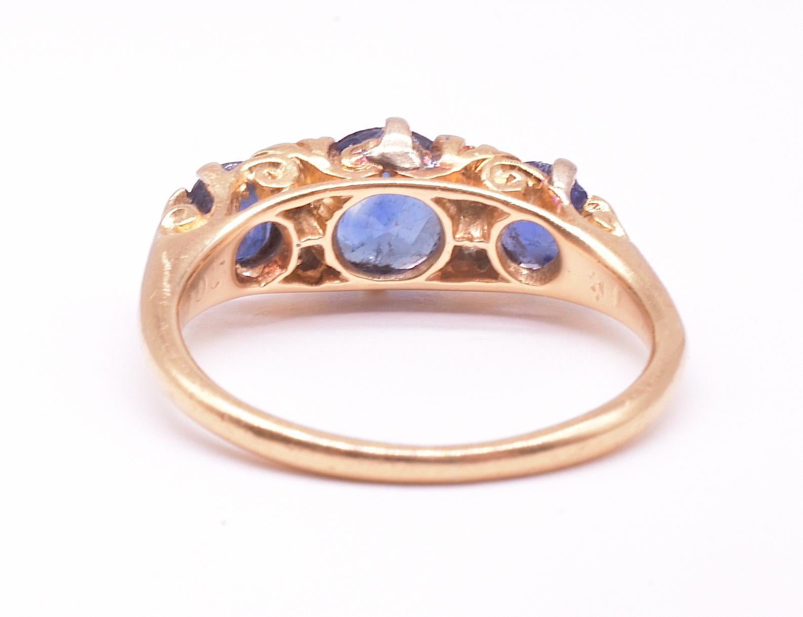 Cornflower blue sapphire claw set ring with three large sapphires with four complimentary old cut diamonds, a variation of the 5 stone half hoop diamond ring (the each pair of small diamonds read as one larger diamond). Such rings were designed to