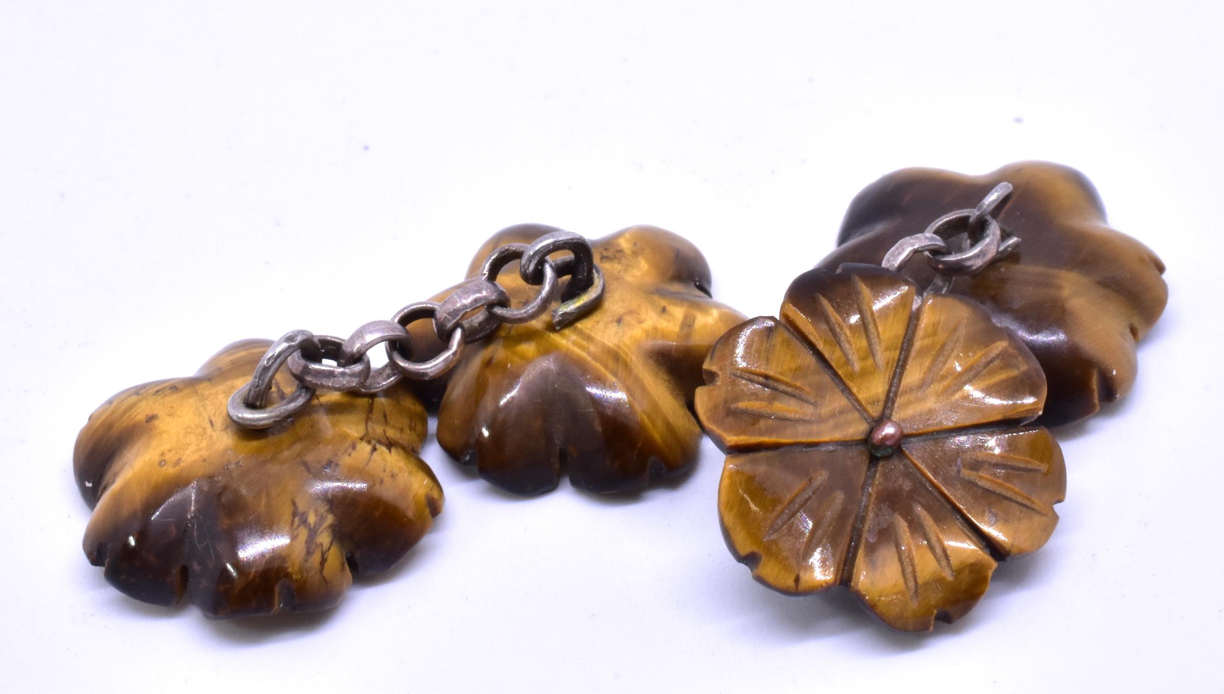 Made of tiger's eye, a yellowish brown chrysoberyl popular in Victorian times, these double sided flower form cufflinks which are linked by a silver chain, have a terrific masculine look that we find especially appealing. Tiger's eye is a little