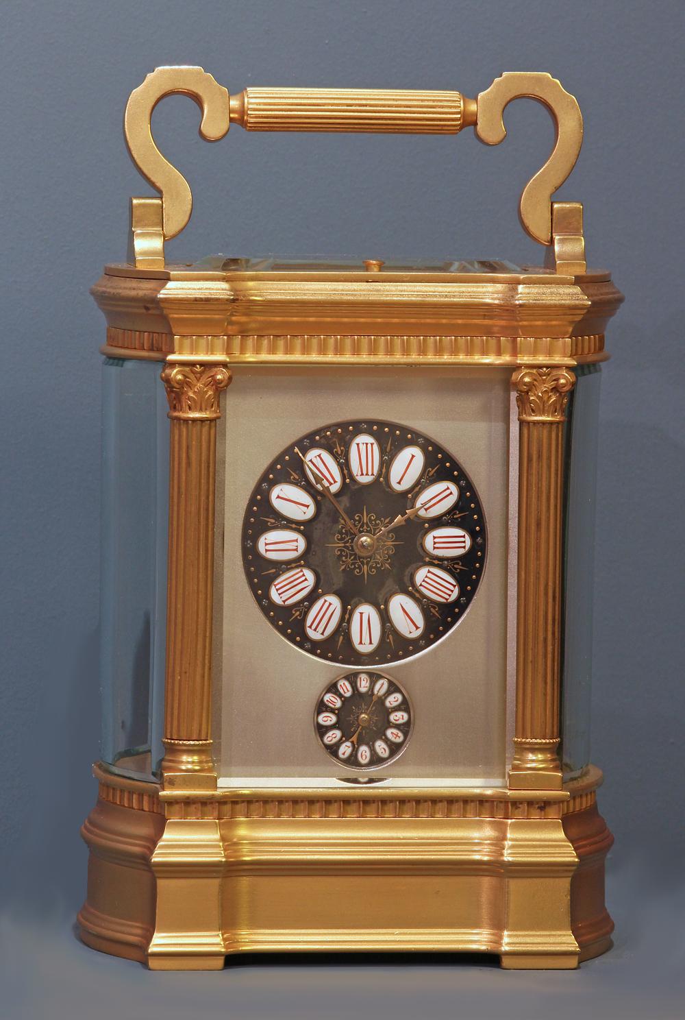 Case: 
The large gilt-bronze bow-sided Anglaise Riche case has fluted Corinthian columns to the corners, a hinged handle, beveled glasses to the sides and a shaped beveled glass above.

Dial: 
The Limoges enamel dials have red Roman numerals on
