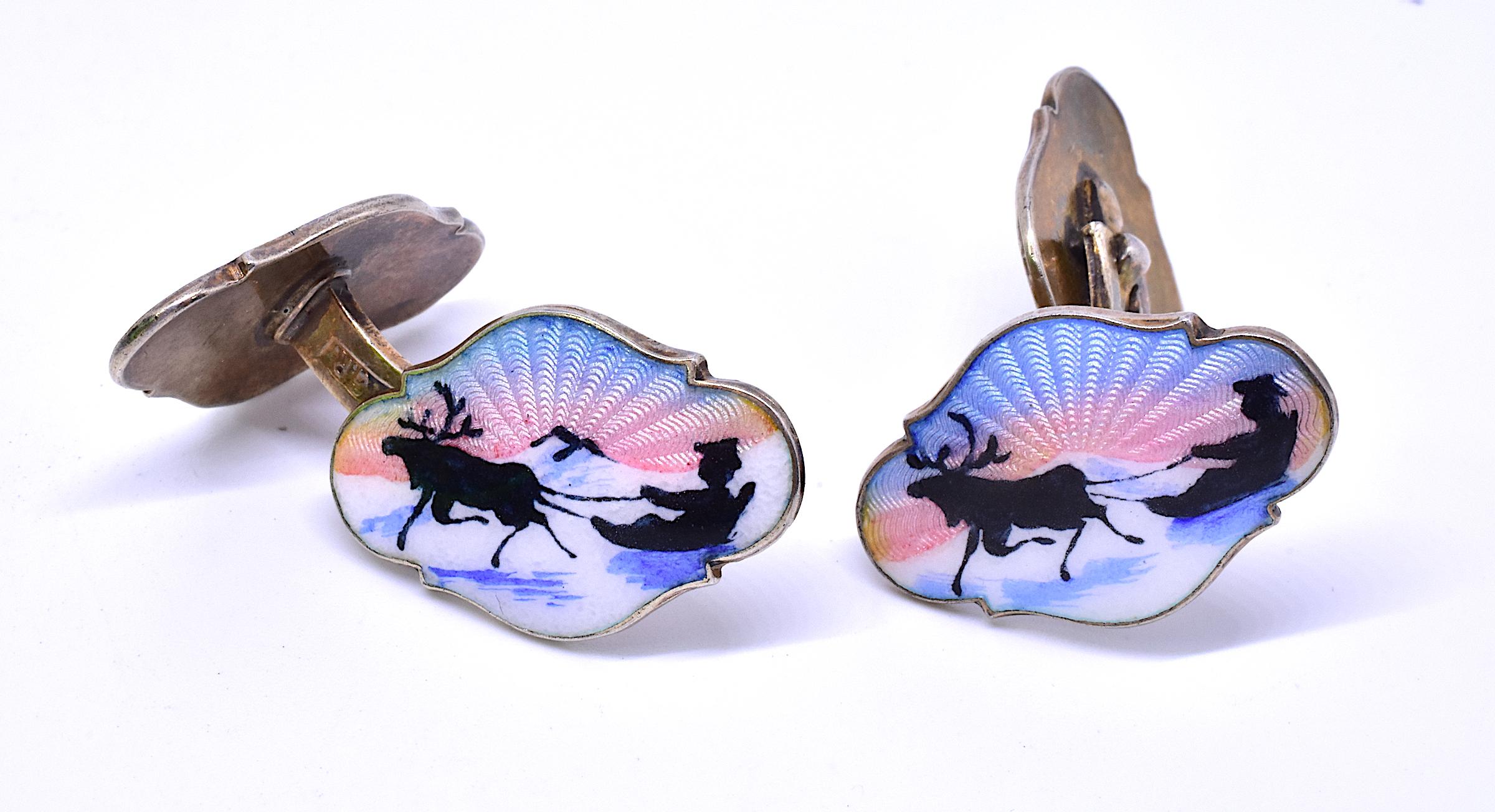 These double sided beautifully colored pastel cufflinks reveal a tree backed landscape and a silhouette of an elk standing in the pasture at sunset. The cufflinks are made of guilloche enamel. The maker is Georg Johannes Ruud, a Norwegian goldsmith