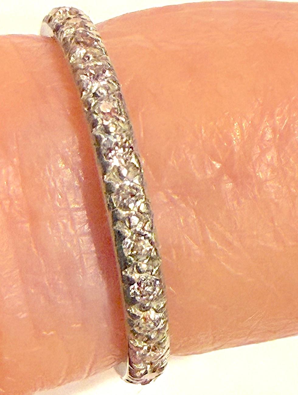 Un bracelet d'éternité en diamant atypique, serti en platine.  Habituellement, les bandes d'éternité de cette période  sont fixés en  l'or.  Les diamants pleine taille de l'ancienne mine pèsent environ 2 points chacun.  La face de l'anneau mesure 2