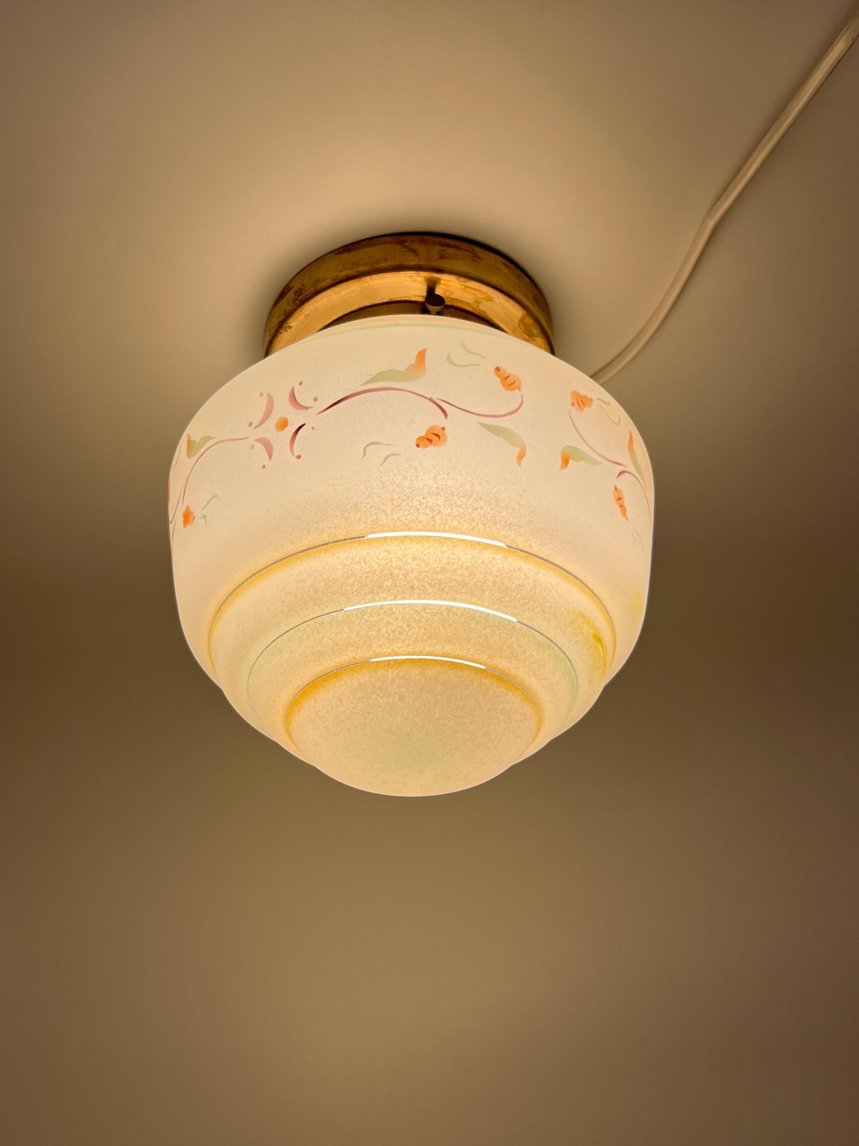 Lámpara de techo Art Decó escandinava, cristal multicolor y latón, años 30

Esta llamativa lámpara de techo empotrada es un vibrante ejemplo de la interpretación escandinava del estilo Art Déco, circa 1930. Presenta una cautivadora pantalla de