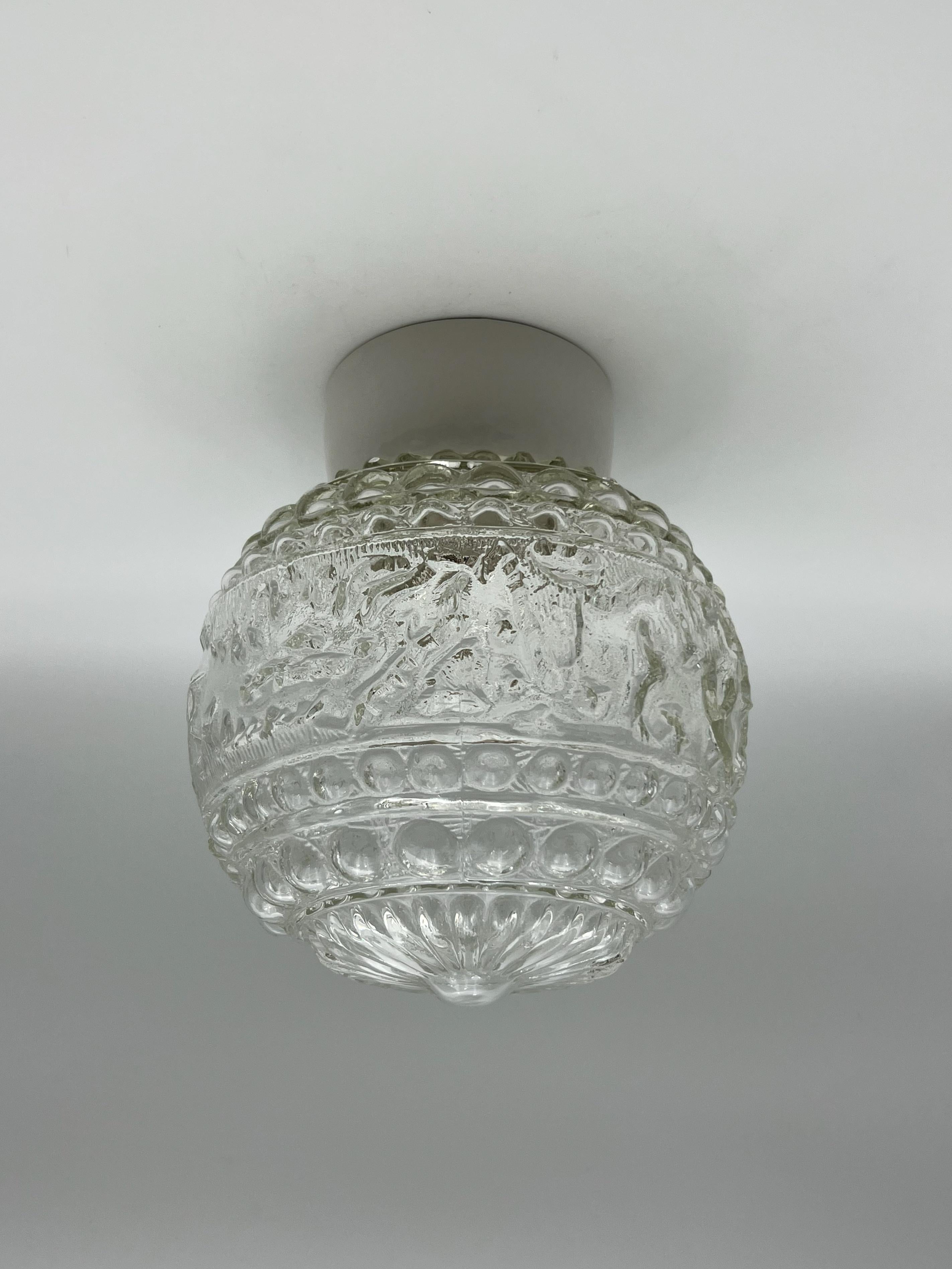 Scandinavian Modern Flush Mount Ceiling Lamp, c. 1940s/50s

This elegant mid-century ceiling lamp features an original domed shade in patterned press glass, mounted on a classic porcelain socket. Its clean, minimalist form and textured glass create