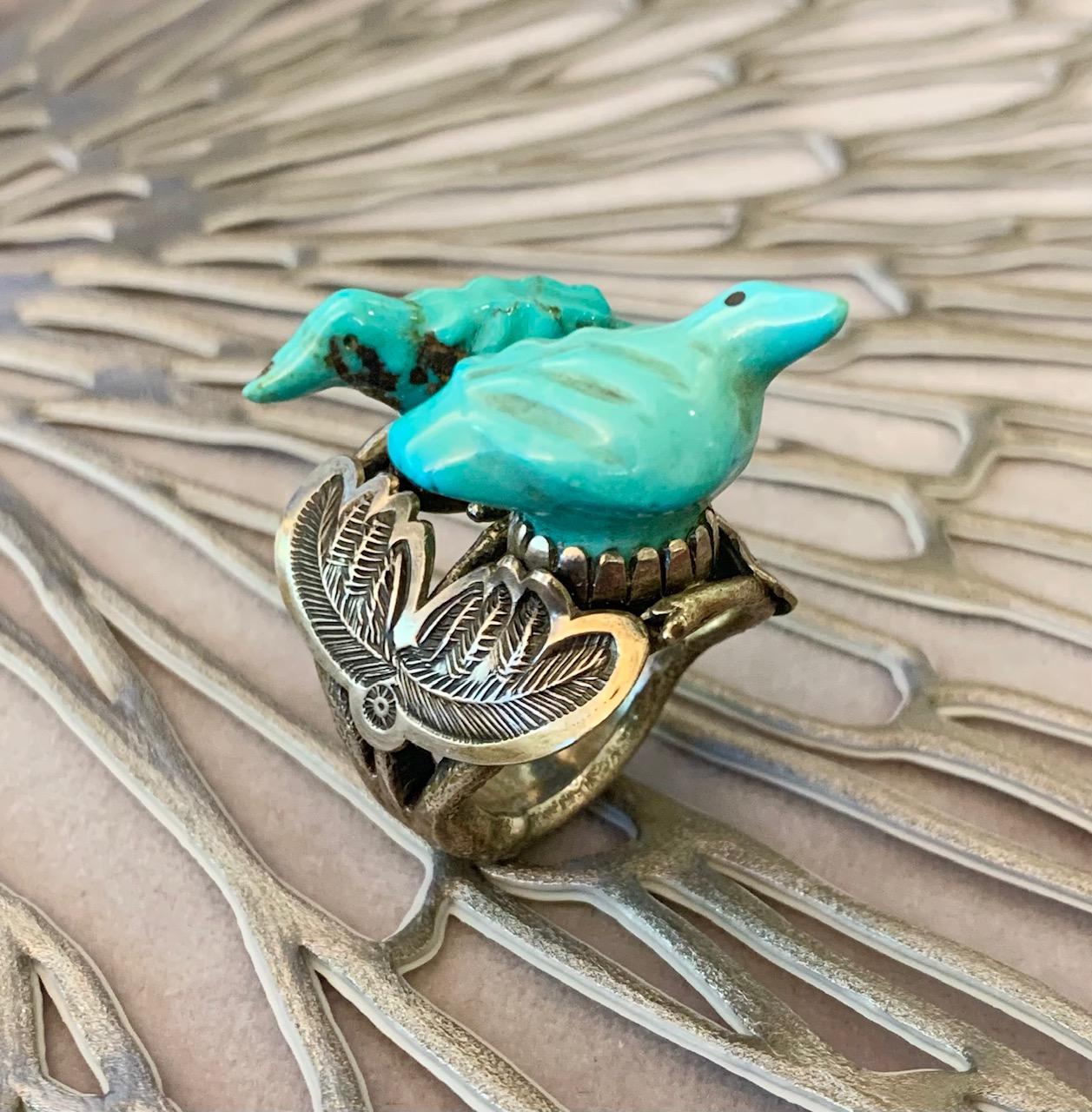 A highly collectible carved turquoise and silver ring, by Zuni fetish carver Leekya Deyuse and Steven Tiffany c. 1940. Stamped ST coin. Size 7.

Leekya Deyuse (Zuni, 1889 - 1966) was a master carver whose work is considered among, if not the most,