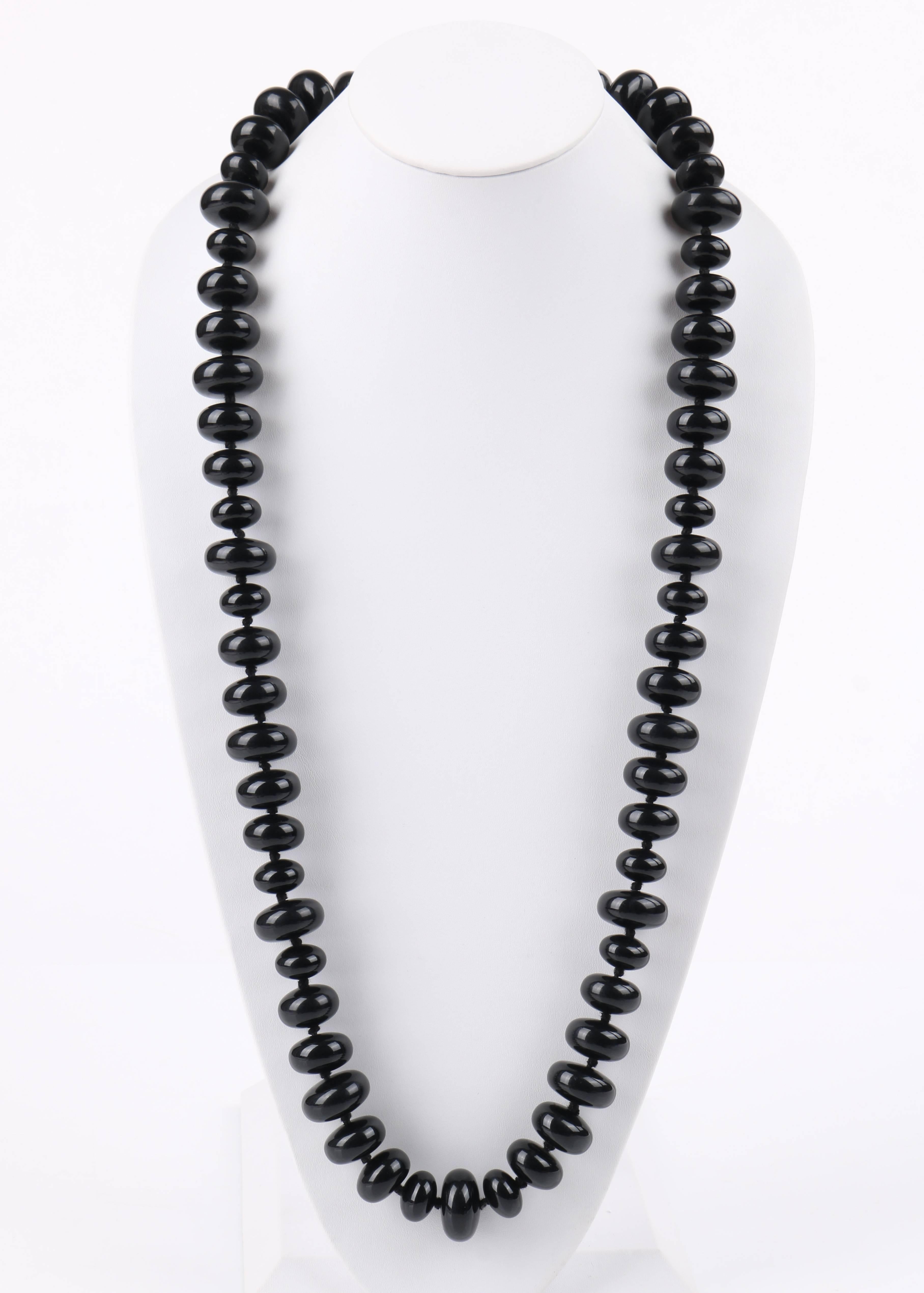 Vintage c.1940's black onxy rondelle beaded lone lucite necklace. Single long beaded strand made up of multiple rondelle shaped lucite beads in varying sizes (17.5 mm - 20.5 mm). Beads are strung onto a black cord with a knot spaced between each