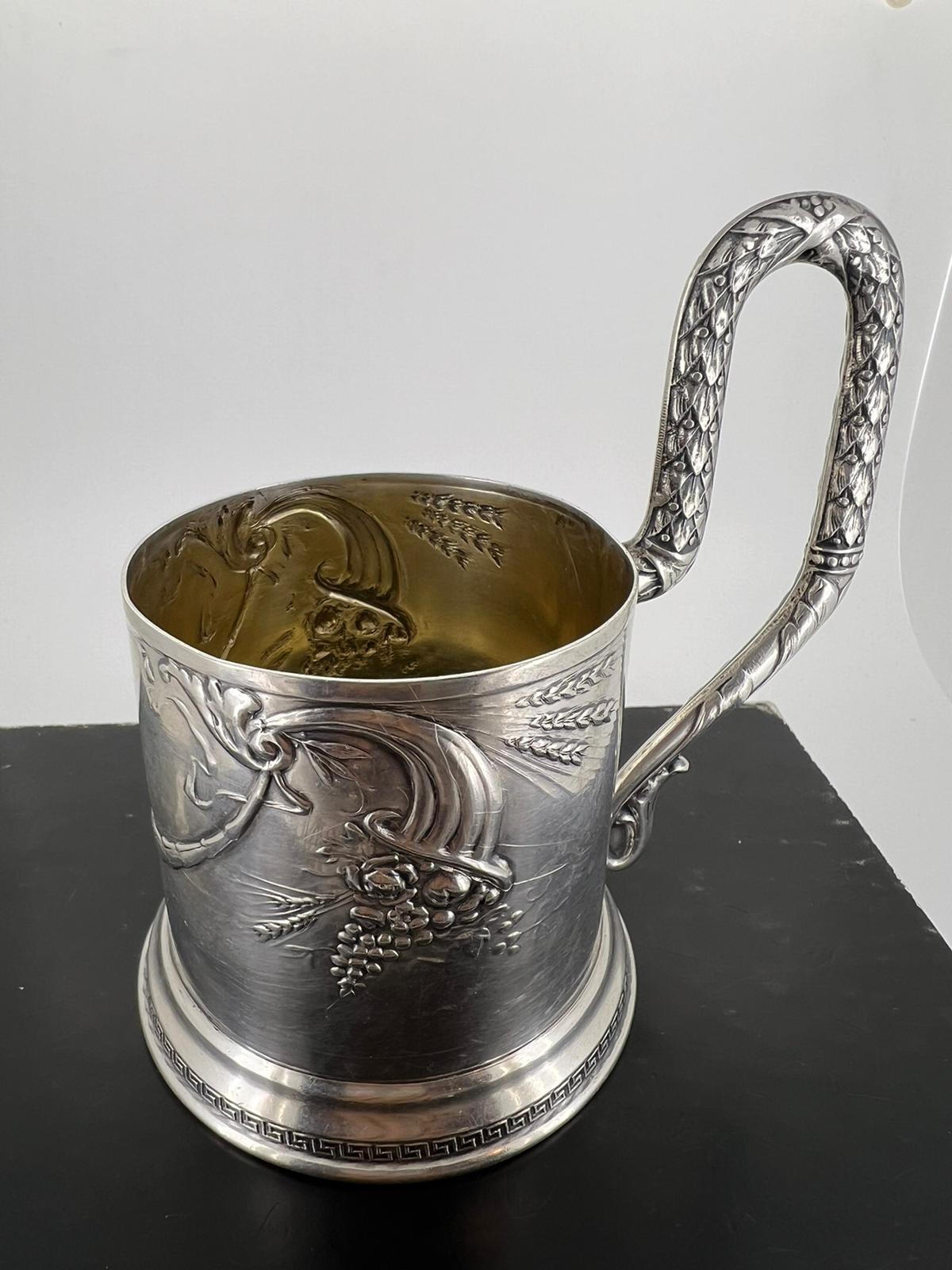 Aufwendig gestaltete Glashalterung, 
mit geprägtem Frucht- und Blättermotiv, 
mit schön detailliertem Griff 

Mit sowjetischen/russischen Punzierungen auf dem Sockel, 
Silber 875 

Gesamtgewicht: 175 gr. 
Höhe: 12 cm 

Sowjetunion, ca. 1940er Jahre.