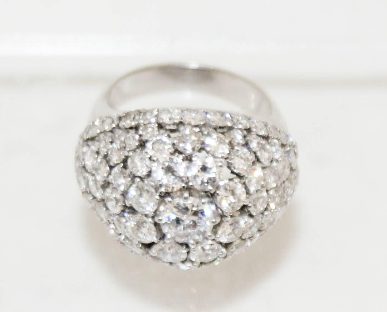 A very fine platinum and diamond bombe cocktail ring, France circa 1950. 
The top of the dome shaped ring is large cluster of round brilliant cut diamonds, surrounded by concentric circles of diamonds. The shank is nicely shaped and makes it