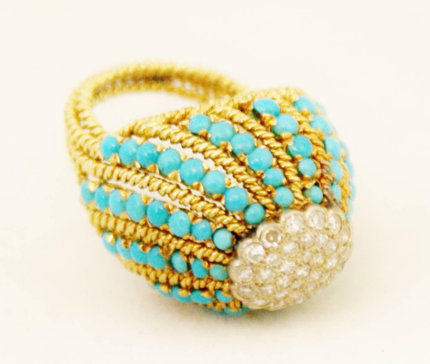 A very fine turquoise and diamond bombe cocktail ring set in 18ct yellow gold.
England circa 1950.
The turquoise are set in a wavy pattern around the central cluster of diamonds that forms the top of the dome. The bombe shape together with the rope