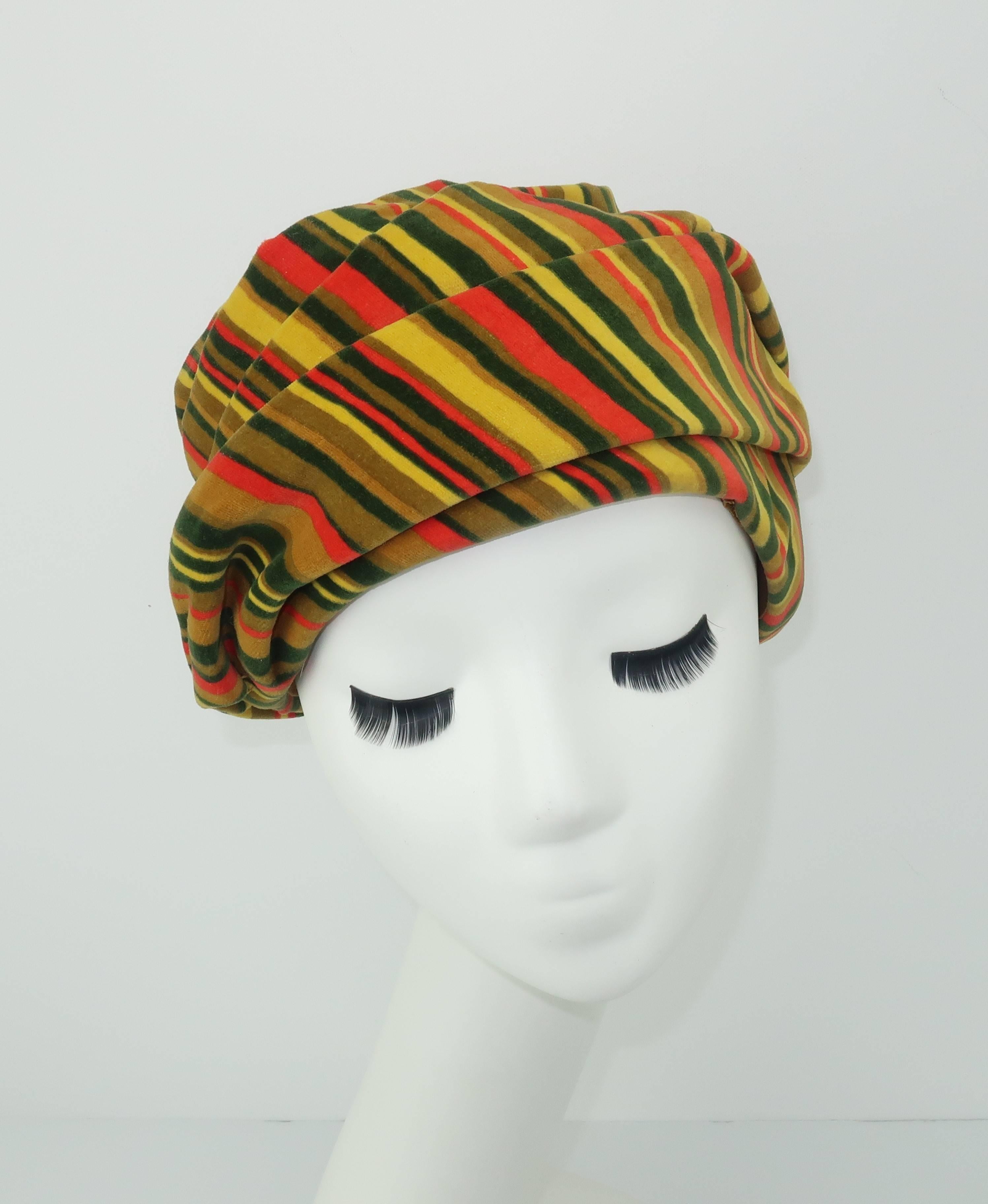 This C.1960 hat by Ken Blair is fabricated from a lush striped velvet in shades of green, yellow and orange.  It is a turban style silhouette expertly folded and stitched into an exotic swirl that is most evident at the crown which takes on the look