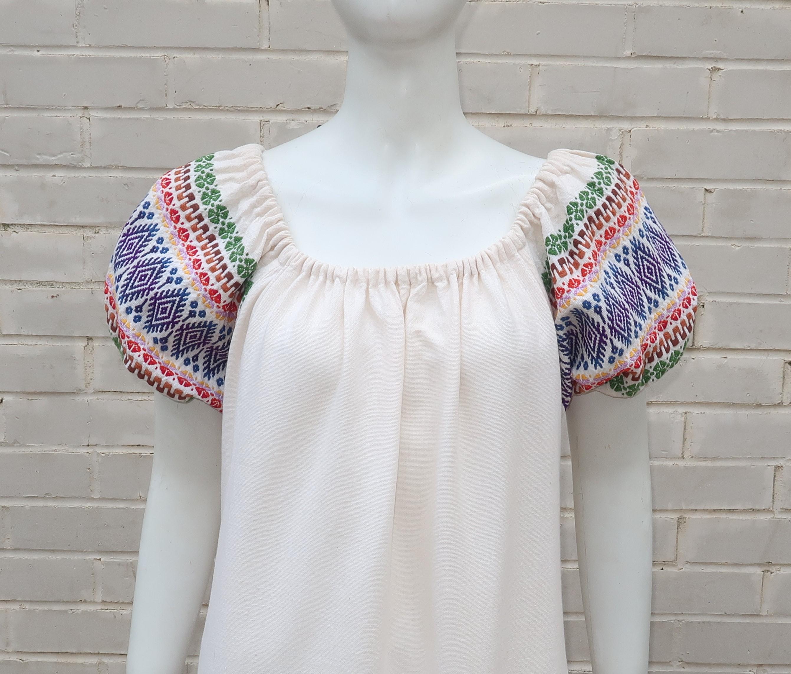 A colorful boho look with a Latin American spin ... this C.1970 Guatemalan maxi dress has an easy smock style silhouette with a relaxed elasticized neckline and short balloon sleeves.  The traditional woven pattern on the sleeves and at the hem
