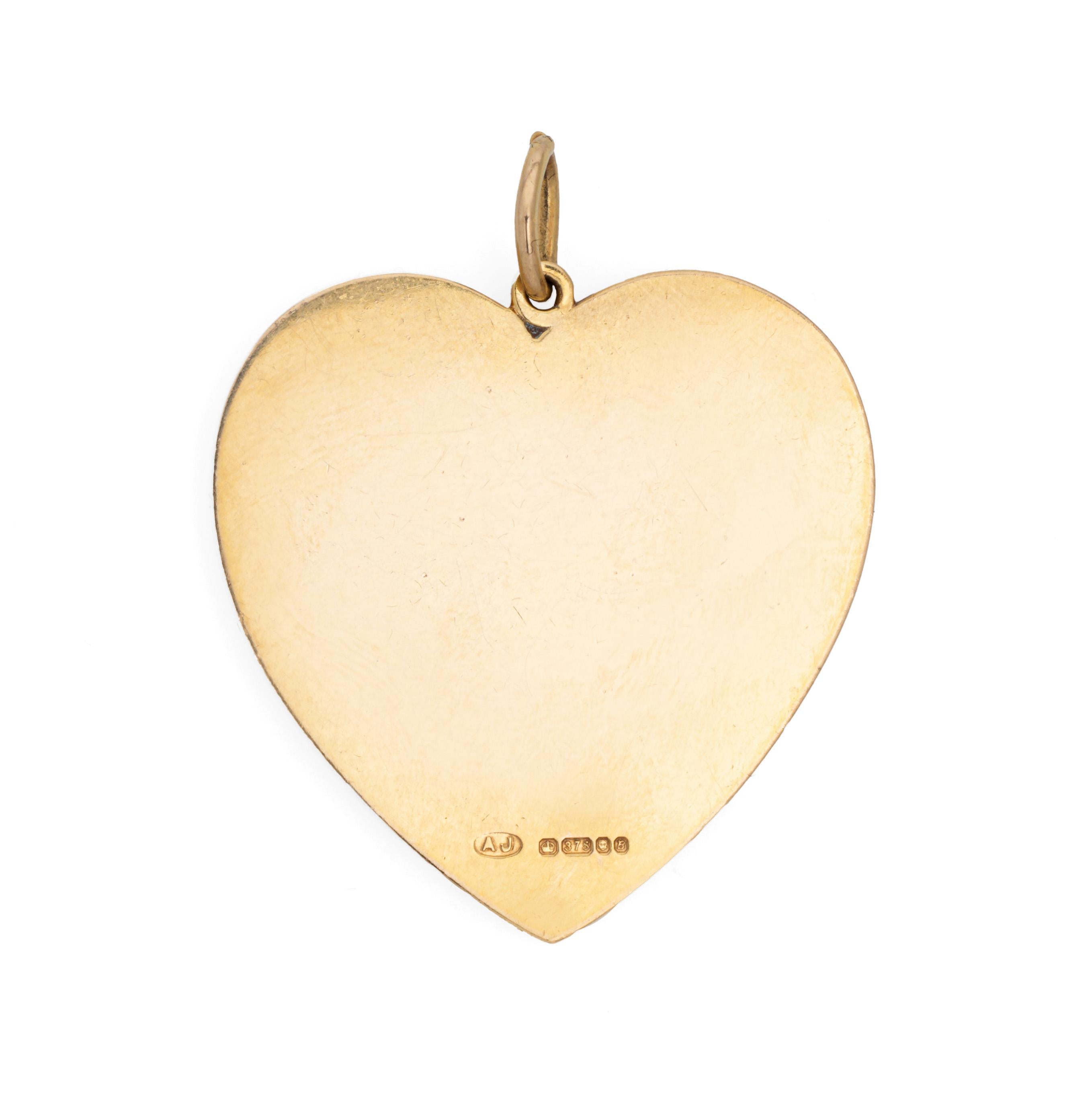Stylish vintage heart pendant crafted in 9k yellow gold (circa 1976).   

With a wedding bell to the center of the large heart, the romantic piece celebrates one of life's big milestones. English hallmarked (see below) in London and dates to 1976.