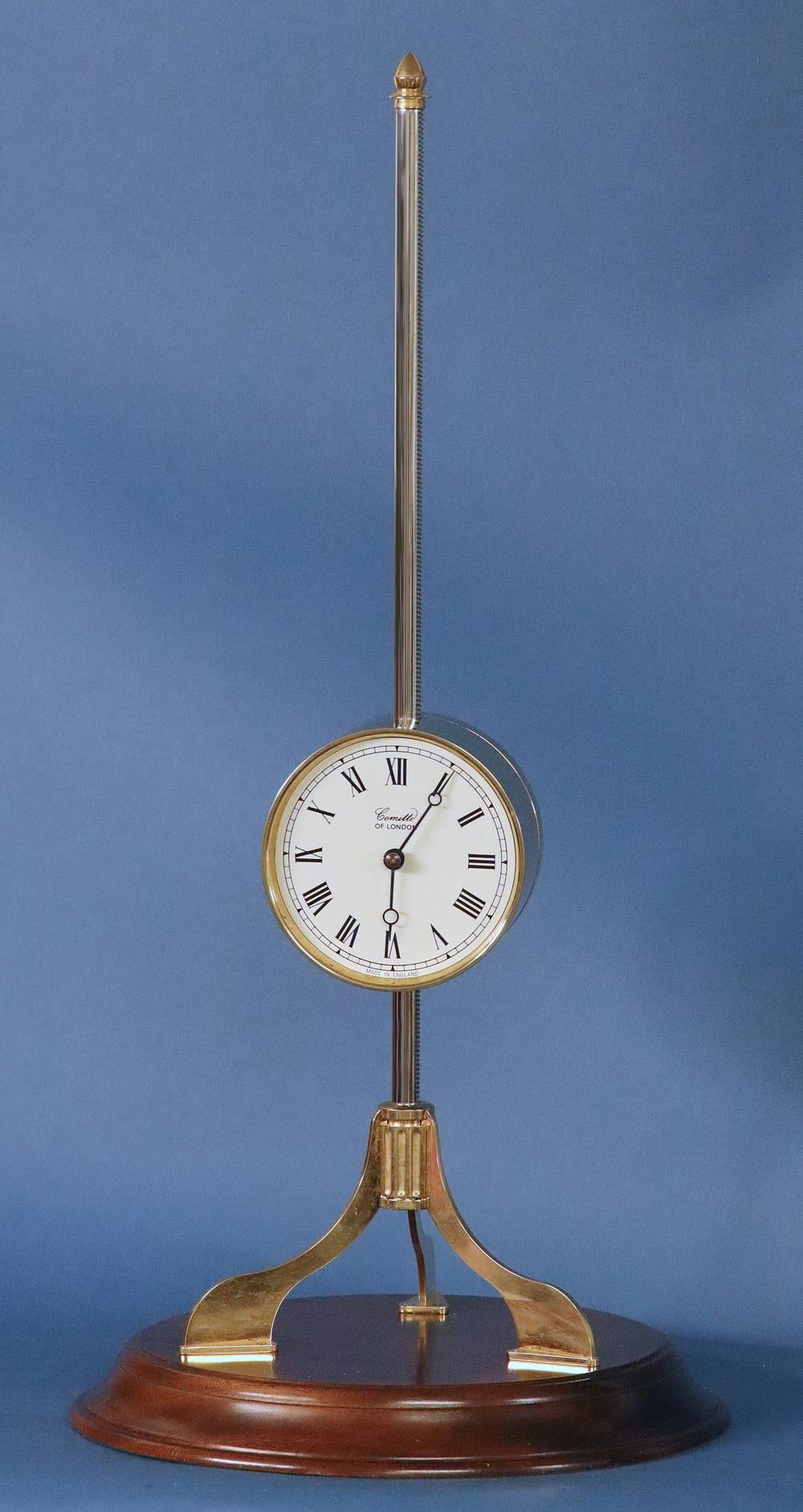 Maker: 
Comitti of London

Case: 
The cylindrical clock is suspended on a stand that sits on three legs and has a steel rod with a sawtooth edge. The whole is mounted to a Mohagany base.

Dial: 
The white dial has Roman numerals for the