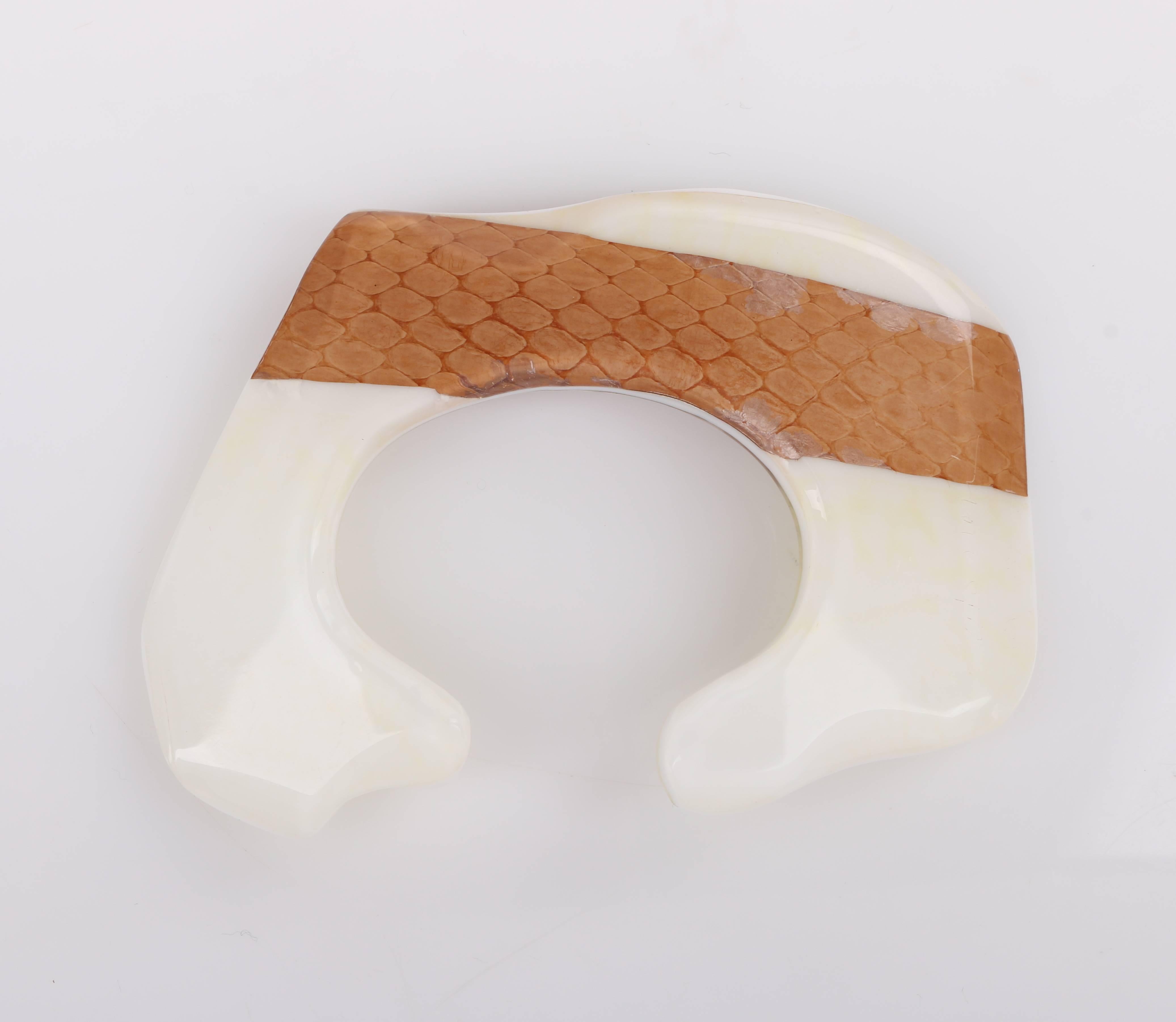 Vintage Anne Vigneri c.1984 snakeskin embedded lucite sculptural cuff bangle. Tan snakeskin embedded in off white lucite. Asymmetrical sculptural shape. Slip-on style. Piece is dated: 