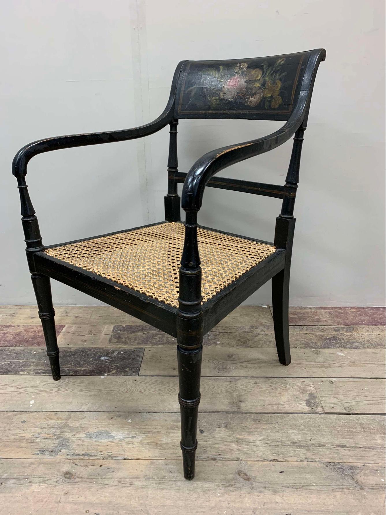 Lovely circa 1830s English black painted open armchair with decorative flower and leaf painted frieze to the back.
The canning to the seat has been redone over time and is in good condition.

A nice chair and with the addition of a squab