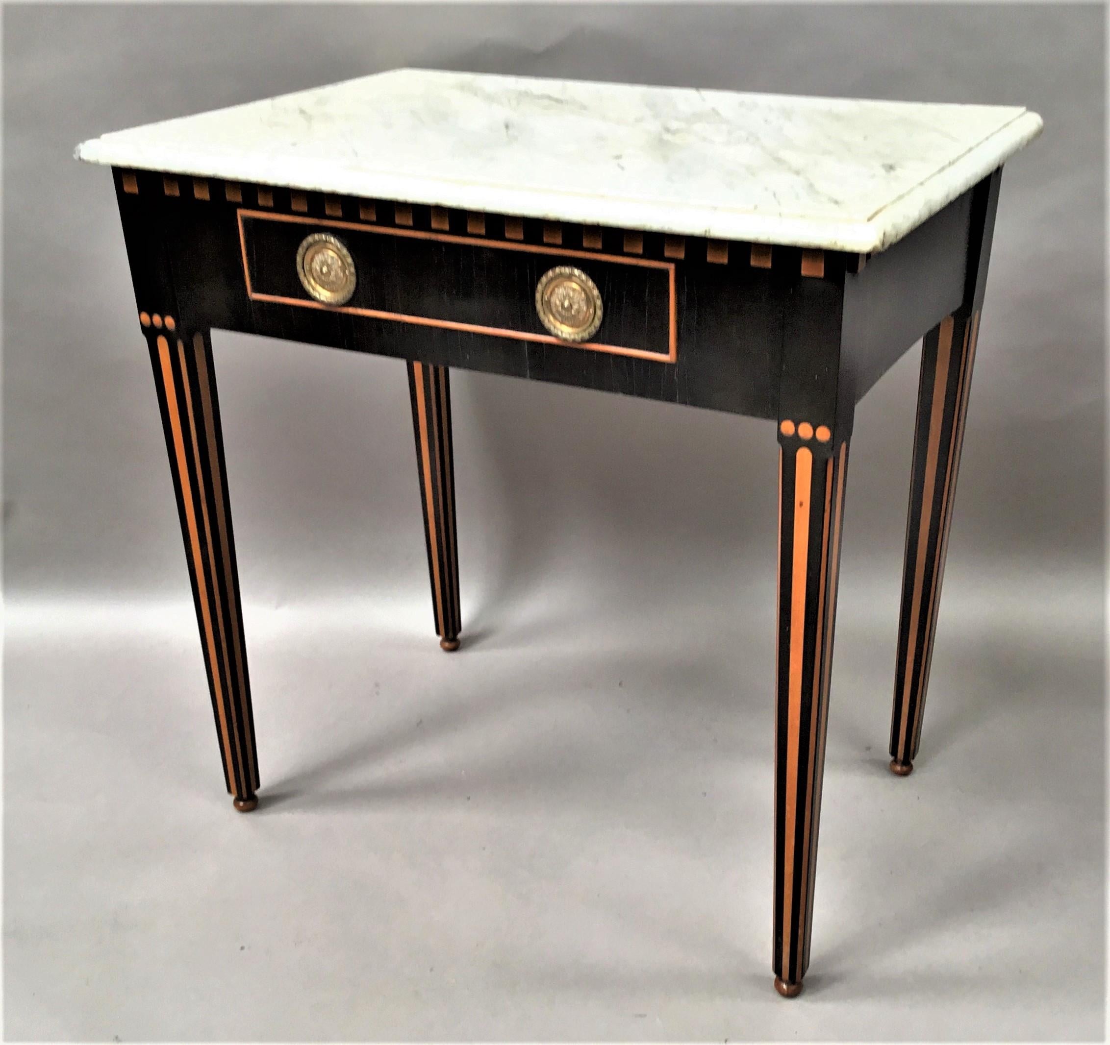 Very smart, early 19th century Dutch ebony and satinwood side table; the original Carrera marble top having a thumbnail moulded edge above the ebony frieze with satinwood dental moulding; the oak lined single drawer with satinwood cockbeading and