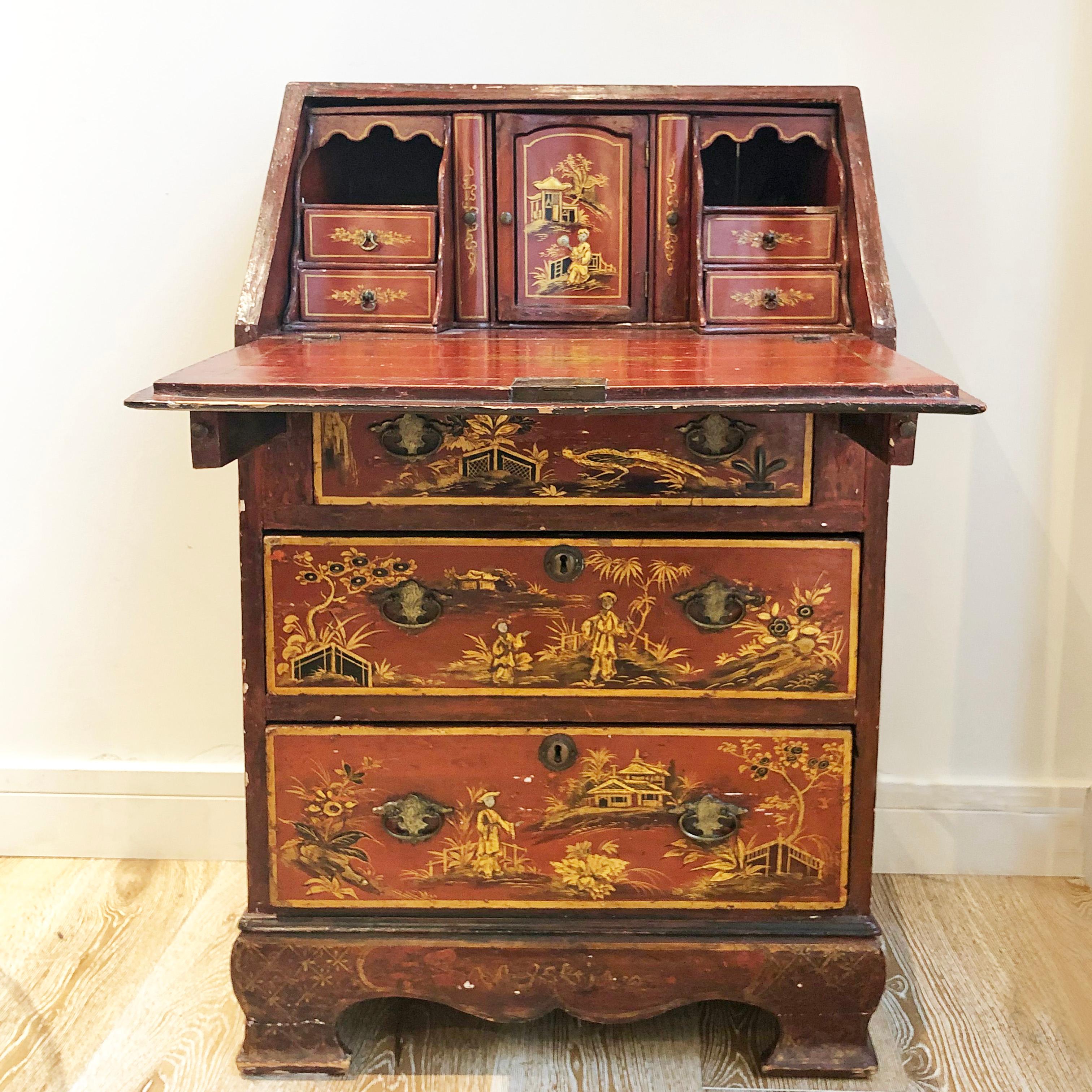 Mid-19th century English writing bureau with oriental detailing. Red painted oak body with 3 drawers and slanted writing surface. A truly unique piece with a variety of drawers with bronze fittings and strap handles inside.

Measures: 56 W x 47 D