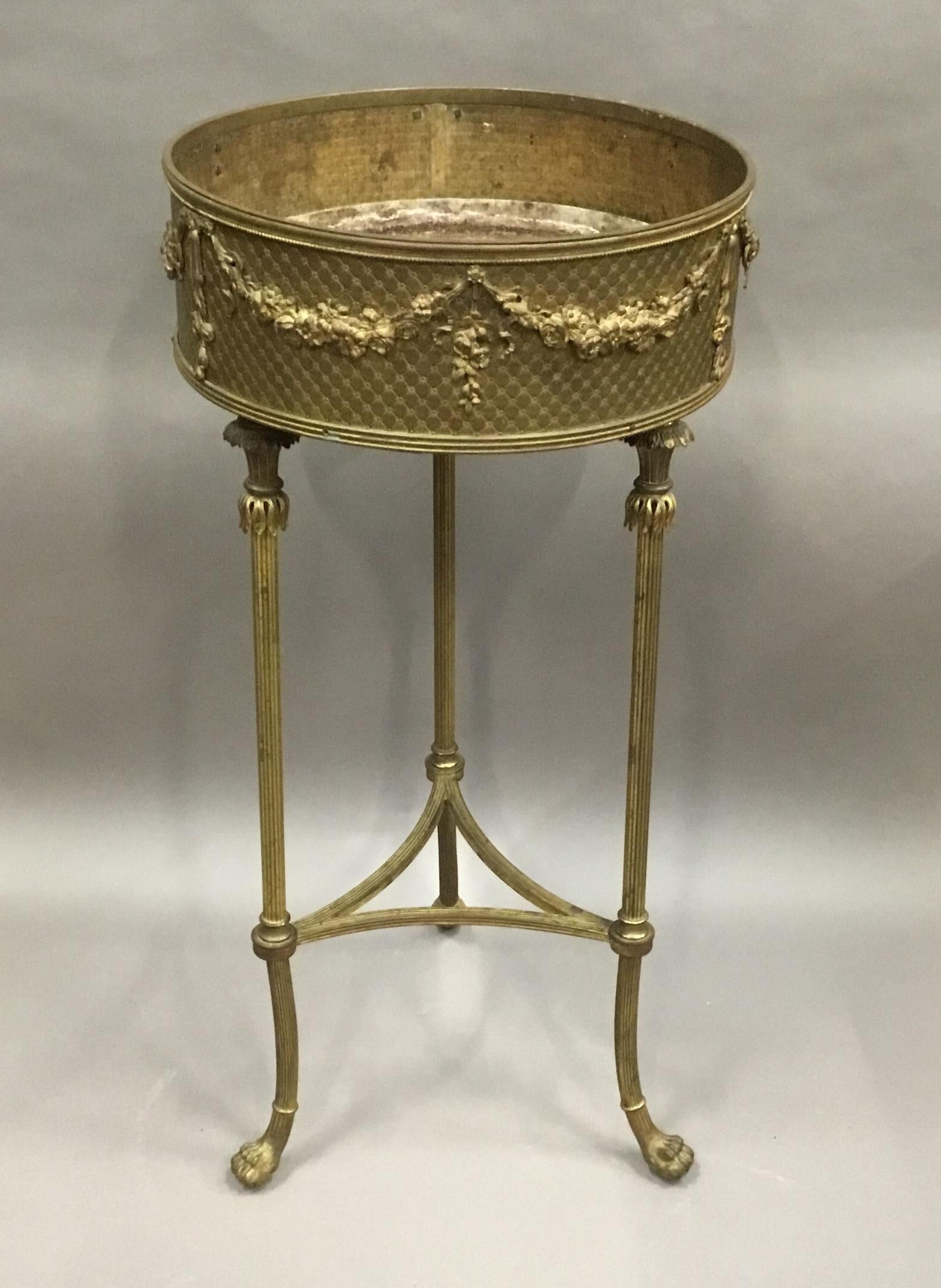 Impressive 19th century French gilt brass jardinière, the circular open top with a fine detailed moulded edge above ribbons and swags festooned with flowers on an unusual quilted trellis work background. Raised on elegant reeded supports, headed