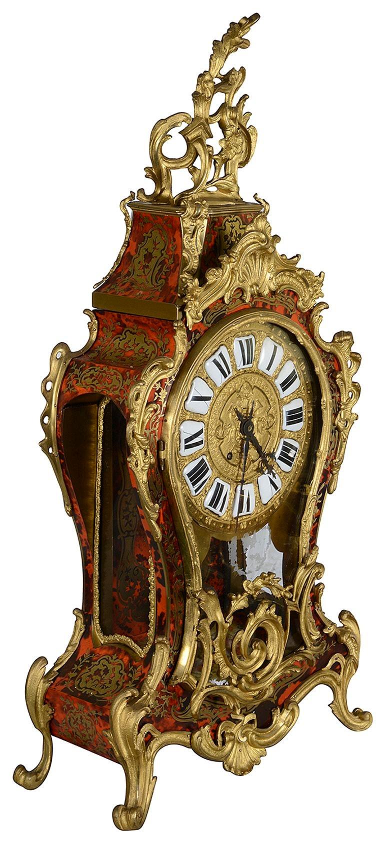An impressive 19th Century French Louis XVI style, Boulle mantel clock, having red stained Tortoiseshell veneer to the case, gilded Rococo influenced ormolu mounts, white enamel Roman numerals. An eight day duration clock striking on the hour and