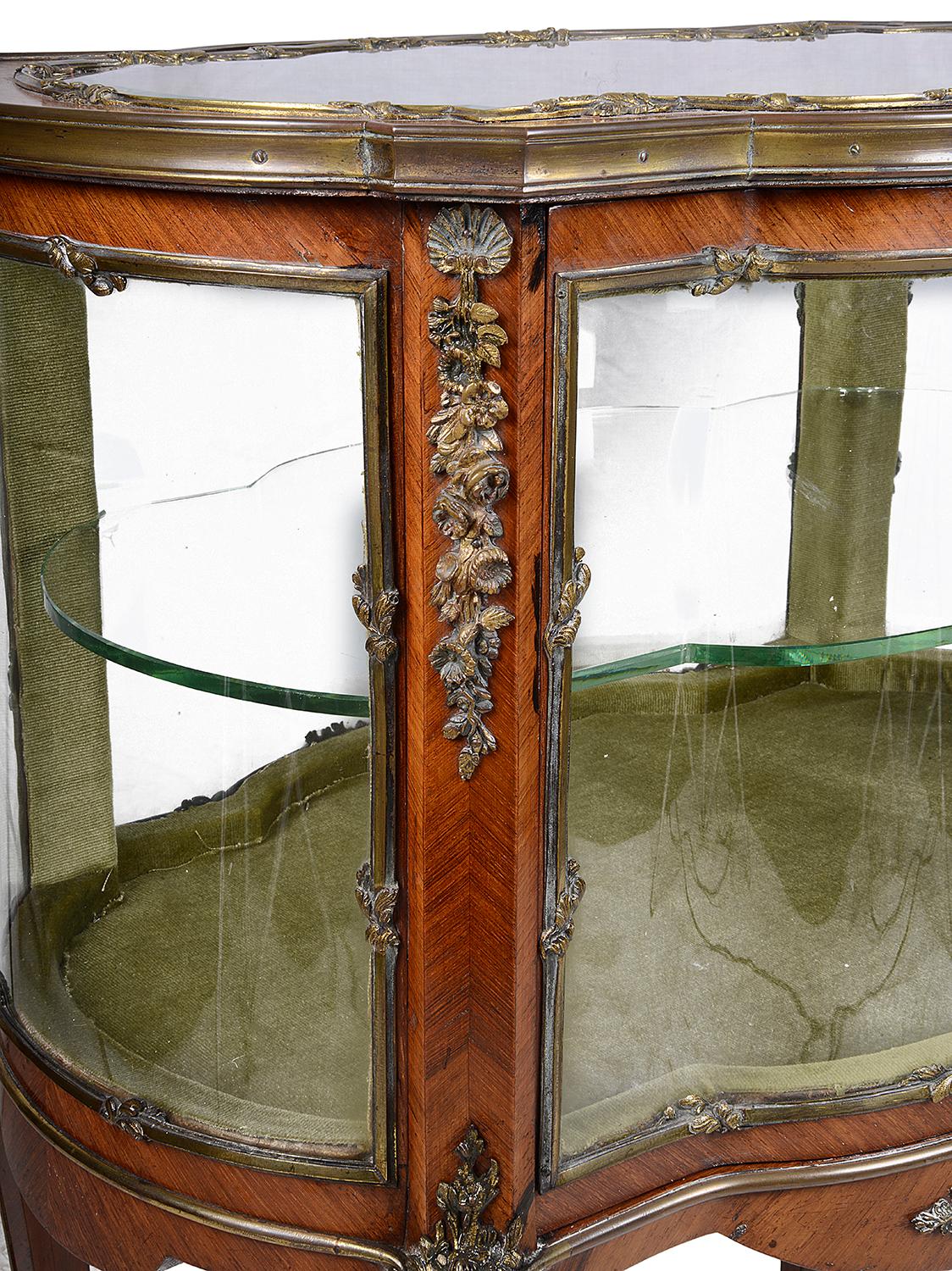 A very good quality late 19th century French ormolu-mounted free standing vitrine. Having bowed glass to the ends, a door to open with a glass shelf within. Classical floral and folate gilded ormolu mounts, raised on elegant cabriole legs and