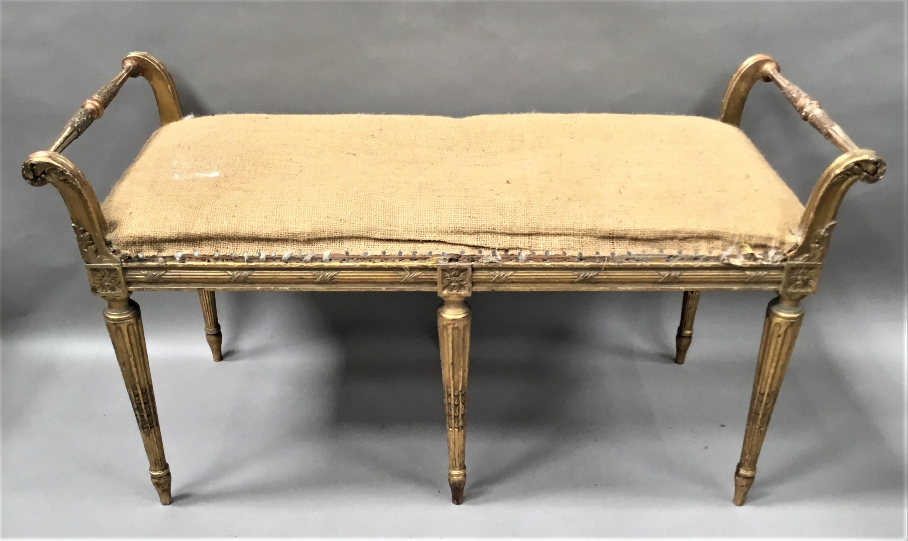 19th century giltwood window seat / stool in the neoclassical manner, finely carved with crisp detail and original gilding; the slender turned end hand rails with acanthus carving and fluted decoration raised on scrolled supports with acanthus leaf