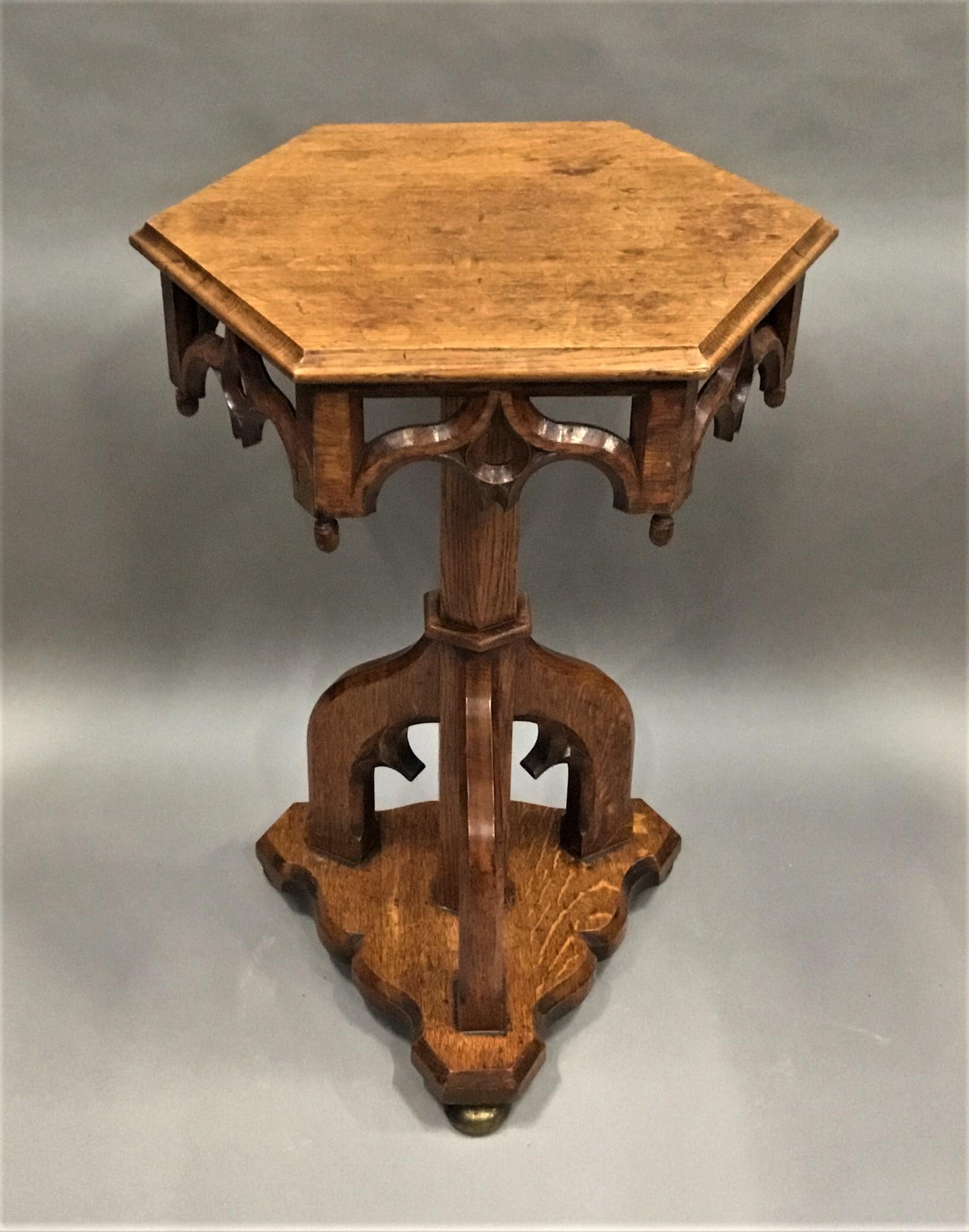 Good unusual 19th century Gothic oak occasional table, the hexagonal top with an ogee moulded edge above the pierced Gothic arch frieze with acorn finials to the corners. The triform base with a hexagonal column on three Gothic arch supports raised