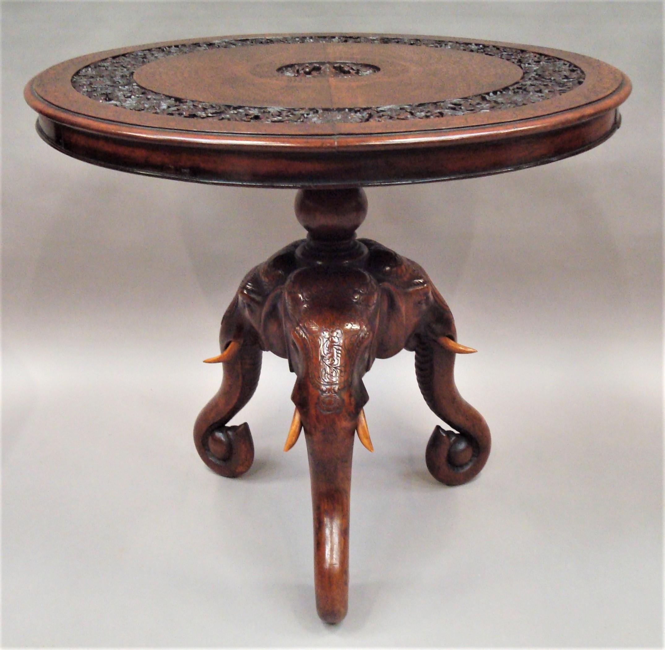Good 19th century Indian finely carved teak elephant occasional table or centre table of very unusual form; the circular top profusely carved with incised geometric decoration with a carved central panel depicting Lakshmi the Hindu goddess. The