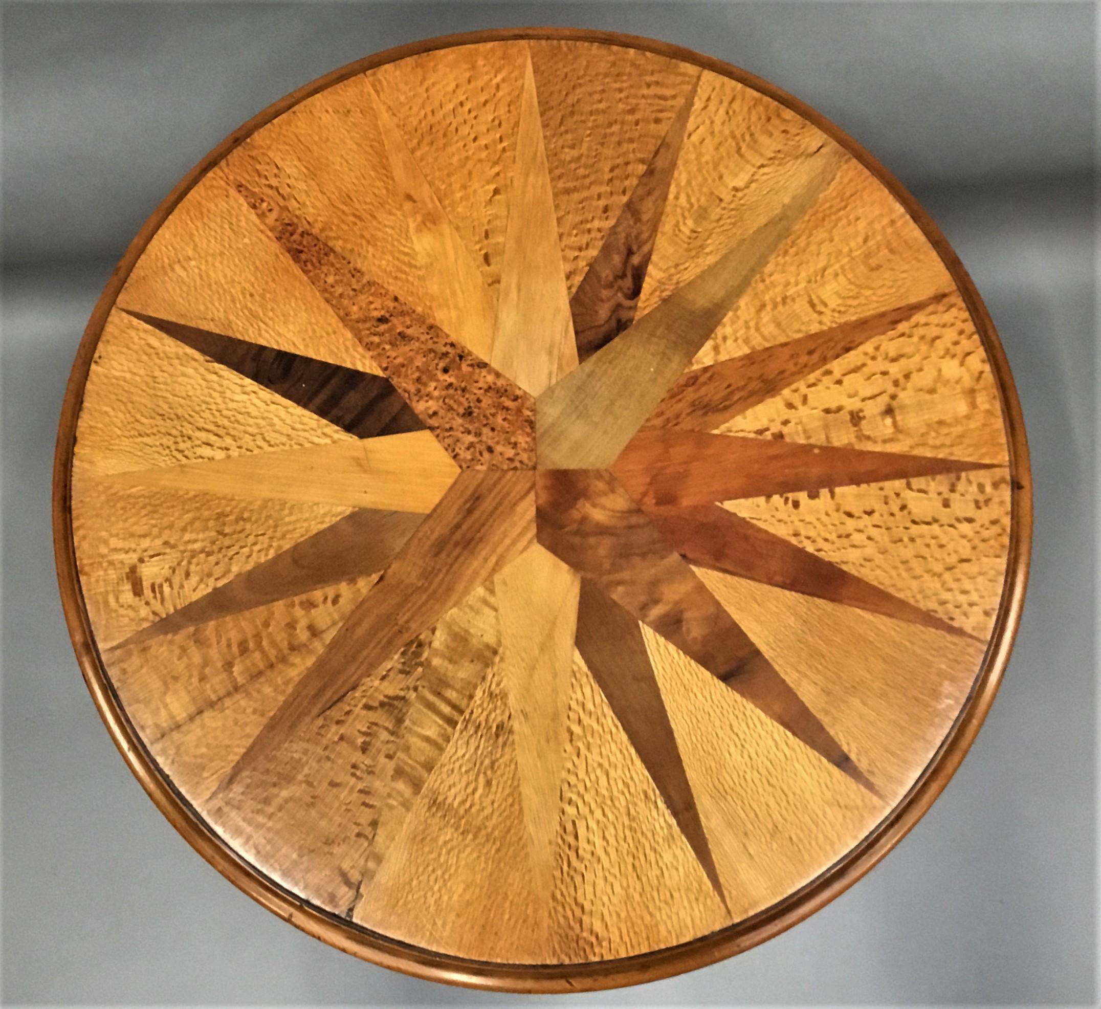 A rare 19th century New Zealand specimen wood table in the manner of Anton Seuffert / William Norrie; the circular top veneered on kauri with numerous indigenous specimen timbers in a segmented radiating design with an ogee moulded edge. Retaining