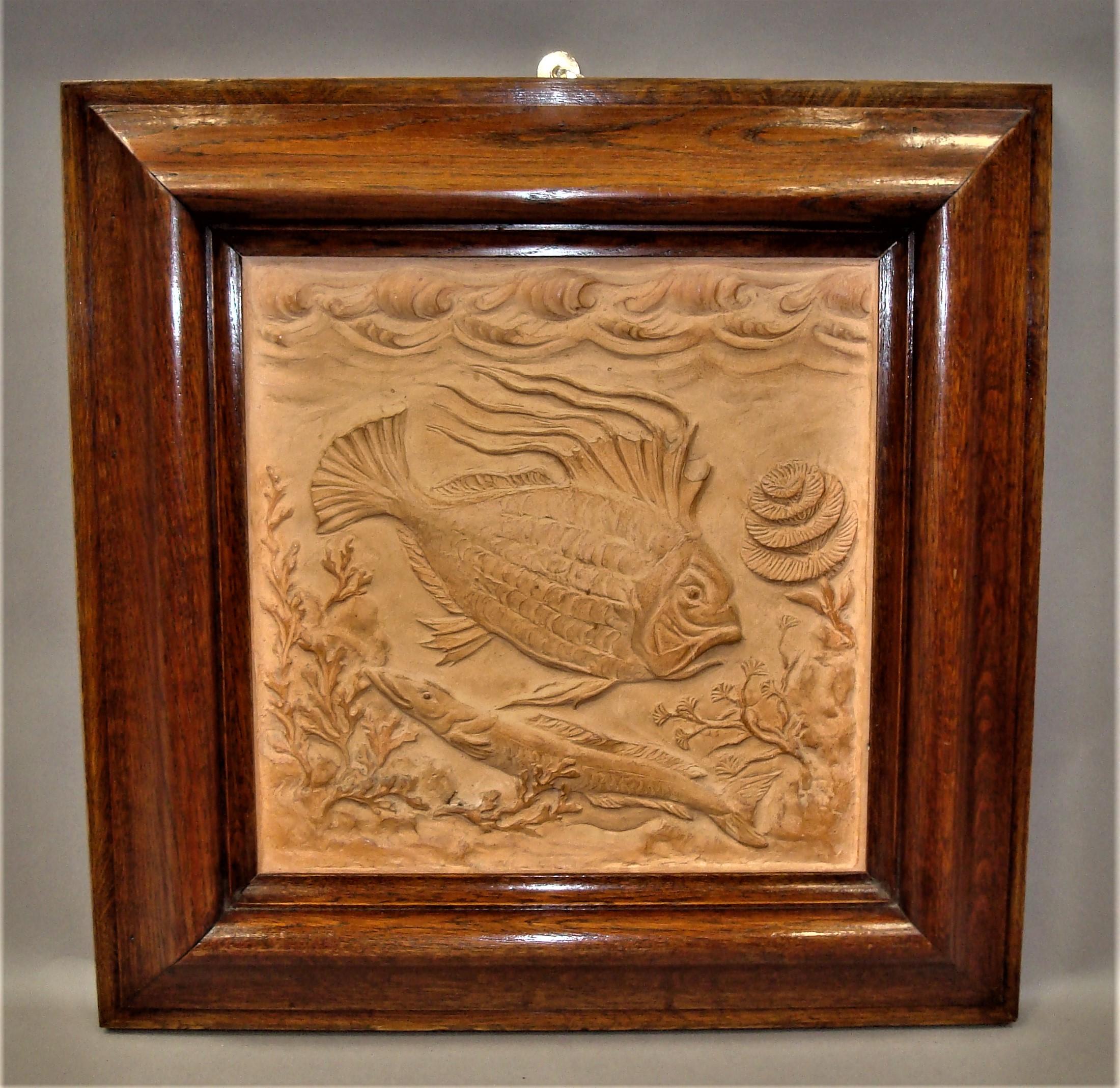 Unusual 19th century pair of terracotta plaques; the square panels finely sculpted each depicting a large swimming fish and sea creature with corals, plants and seaweed. Housed in a bold ogee moulded frame which have a good colour and