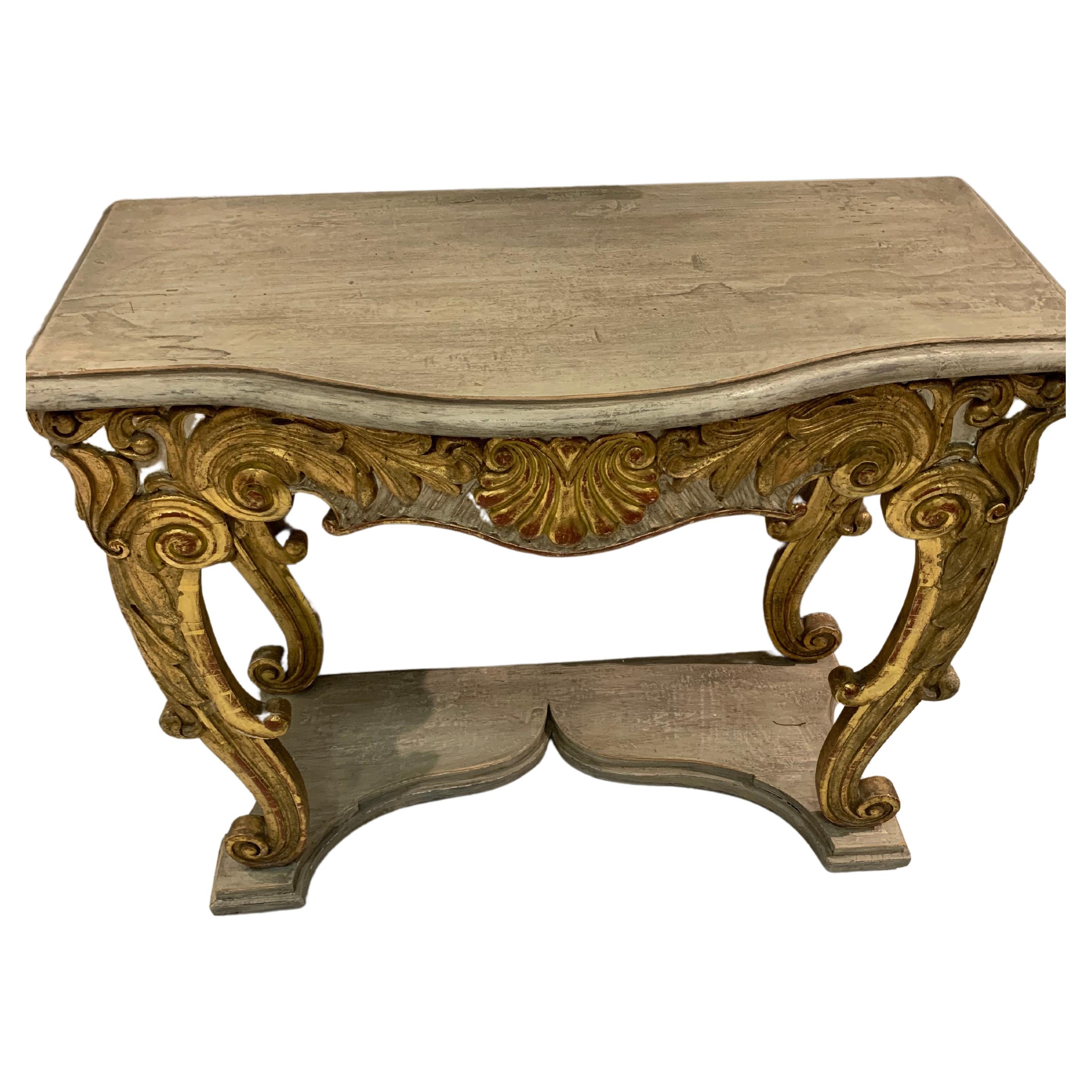 Circa 1850 Swedish rococo style console table.
This decorative piece has gilded scroll detailing and legs with a shell decoration to the centre.
The base and drop in top are painted which has been refreshed and restored at some point in the past.