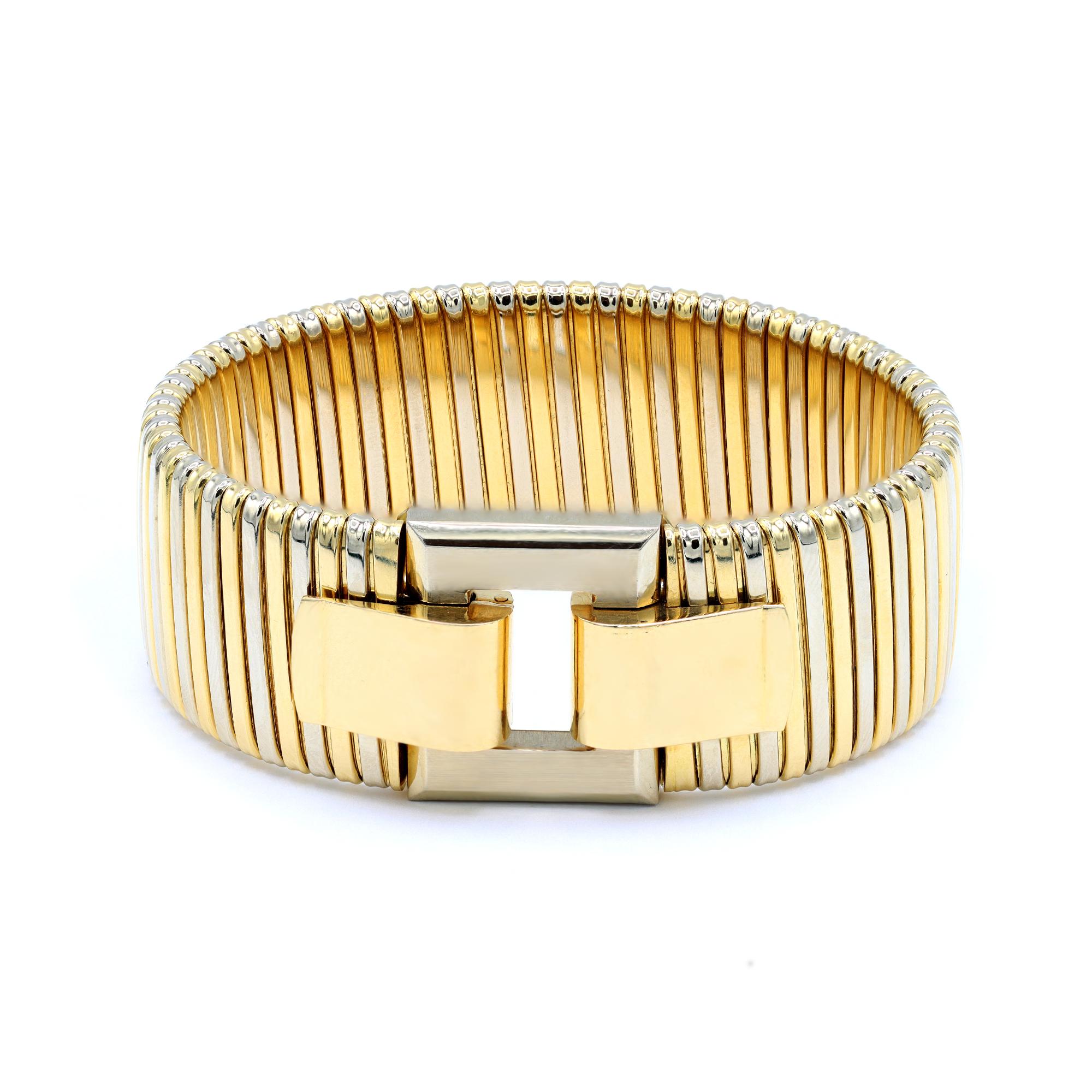 A vintage Tubogas style bangle bracelet originated in Italy circa 1980. The bracelet is made in two tone 18 karat yellow and white gold and closes with an elegant buckle and it is stamped with hallmarks. The gross weight of the bracelet is 79.2