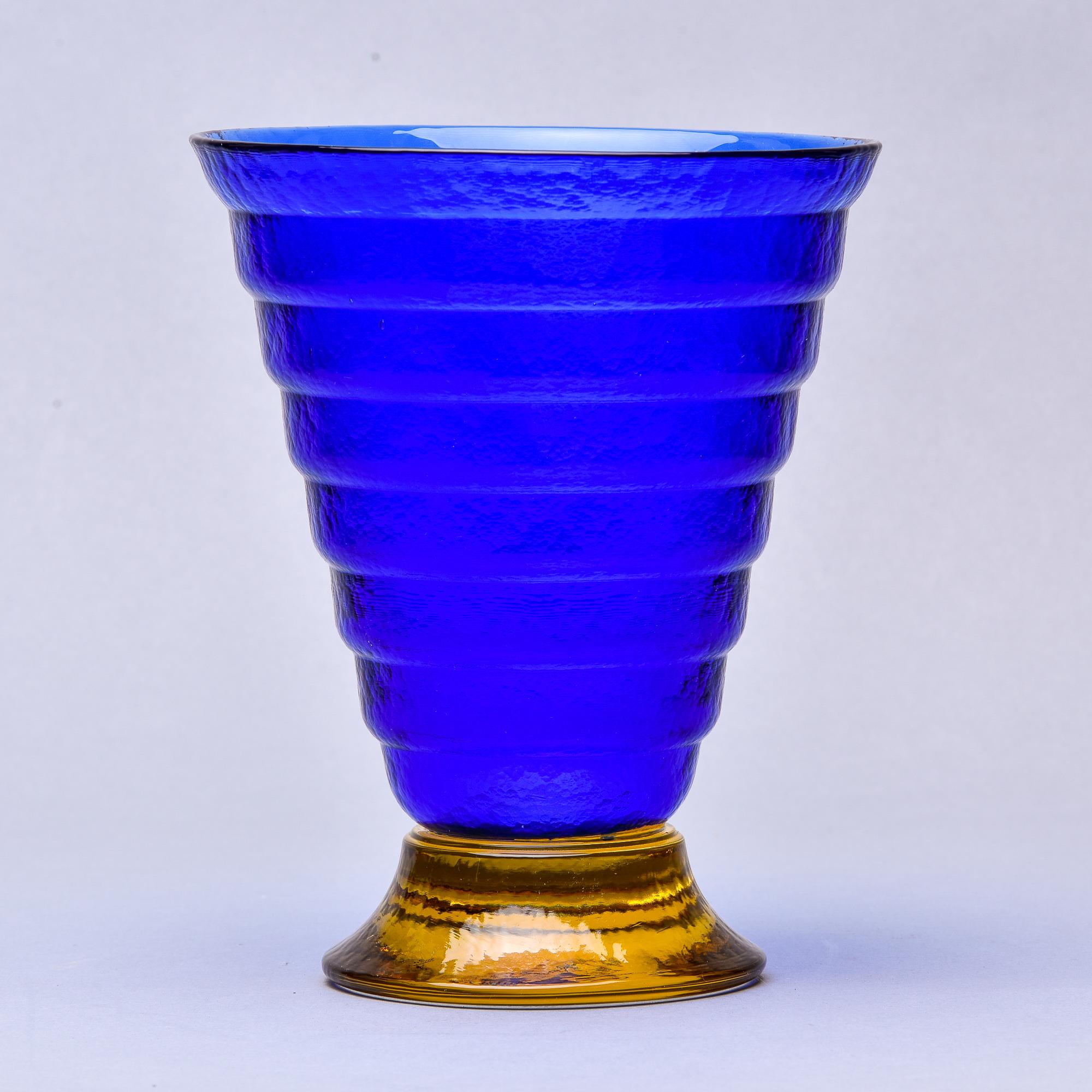 Deep blue Murano glass vase with gold base.

Found in Italy, this circa 1960s Murano glass vase features a saturated heavy blue flared and ridged body on a pedestal base in a contrasting gold. Acid etched maker’s mark on underside of base reads: