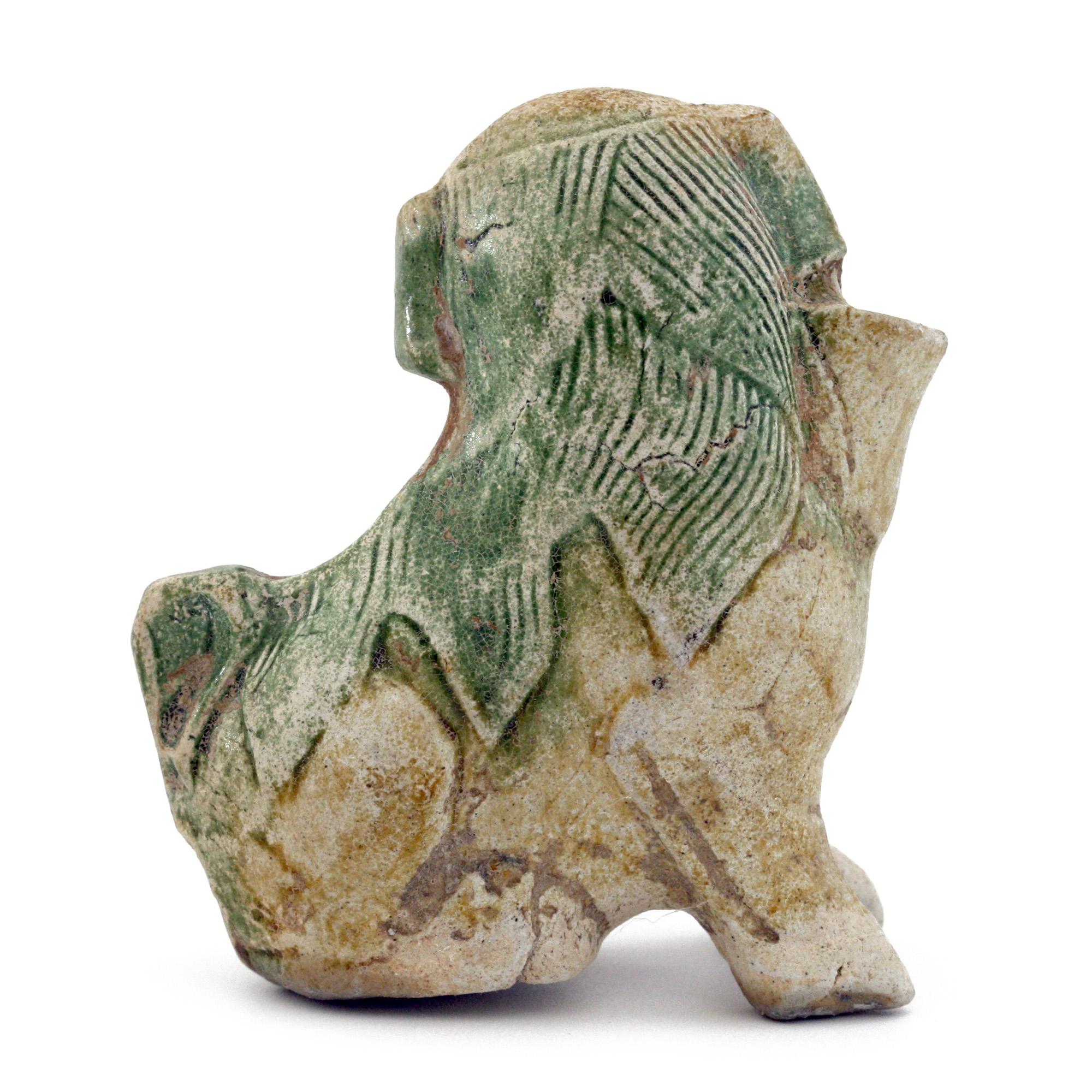 A delightful antique Chinese Ca Mau shipwreck pottery Fo Dog joss stick holder, partially decorated in green glazes and dating from around 1725. The dog has finely detailed features and glances sideways and has an original Sotheby's CA MAU - BINH