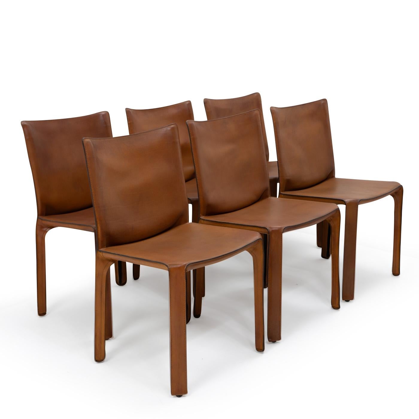 Set of six Cab 412 side chairs in patinated brown leather by Mario Bellini for Cassina.

The Cab chair is built up as a tubular frame over which thick saddle leather is fitted; the leather skin is kept in place with zippers on the inside legs.

A