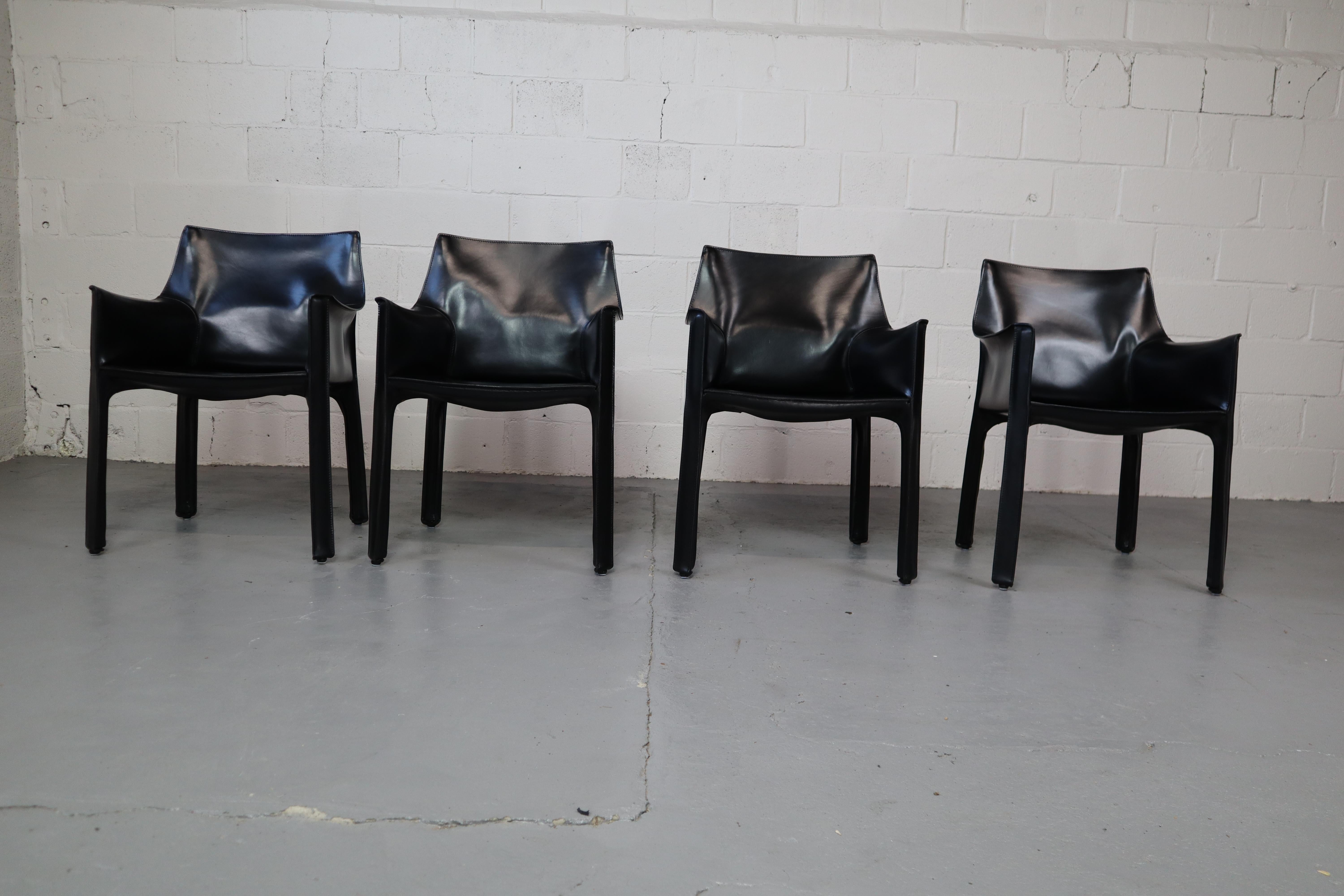 Set of four iconic Cab 413 armchairs in original black leather. Designed by Mario Bellini for Cassina in 1979!

The Cab chair is built up as a tubular frame over which thick saddle leather is fitted; the leather skin is kept in place with zippers on