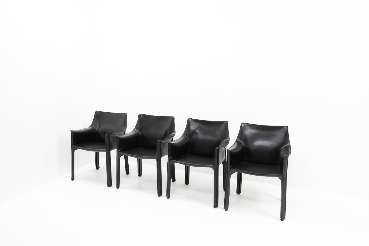 Set of four Cab 413 arm chairs in black leather by Mario Bellini for Cassina.
The Cab chair is built up as a tubular frame over which thick saddle leather is fitted; the leather skin is kept in place with zippers on the inside legs.

A wonderful