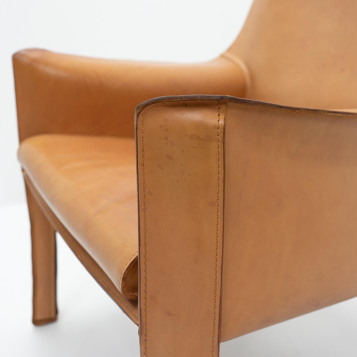 Two Cab 414 armchairs in cognac leather by Mario Bellini for Cassina.

These very comfortable lounge chairs are built up with a tubular steel frame over which foam and thick saddle leather is fitted. The leather skin is kept in place with zippers on
