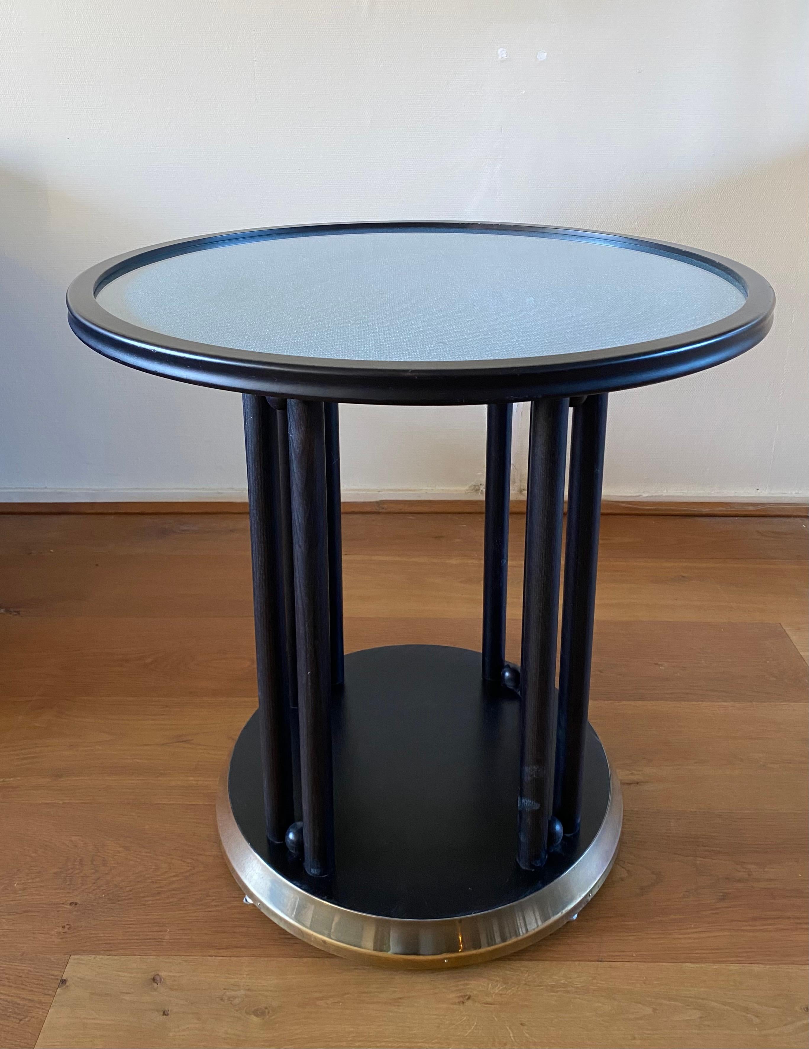 Impressive table, originally designed in 1907 by Josef Hoffman for the Cabaret Fledermaus and manufactured in the 1960s by the Austrian manufacturer, Wittmann. The table features a beechwood frame with a brass-lined base and glass top. Underneath