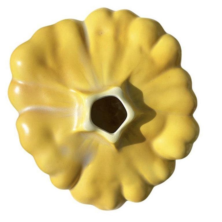 A small yellow ceramic squash vase by Fitz and Floyd. This small vessel is the perfect size for a very small arrangement of flowers. (Think one or two stems) It is low and will add a pop of color to any side table or coffee table. (Or in a bedroom