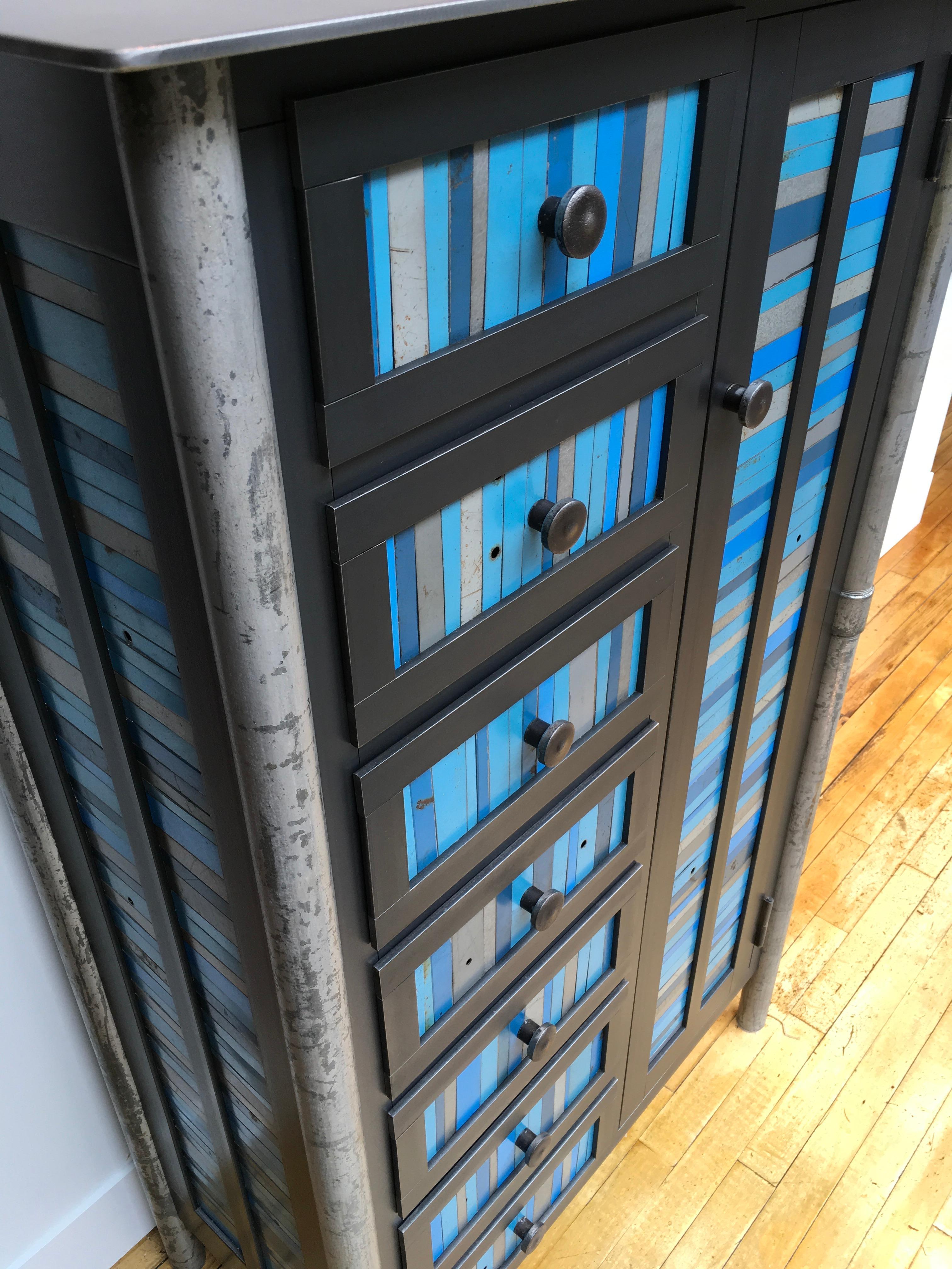 This is a totally functional industrial modern cabinet and case of seven drawers. There are two interior shelves inside the cabinet. It created from hot-rolled steel and found painted panels. The legs are made from salvaged pipe. The panels on the