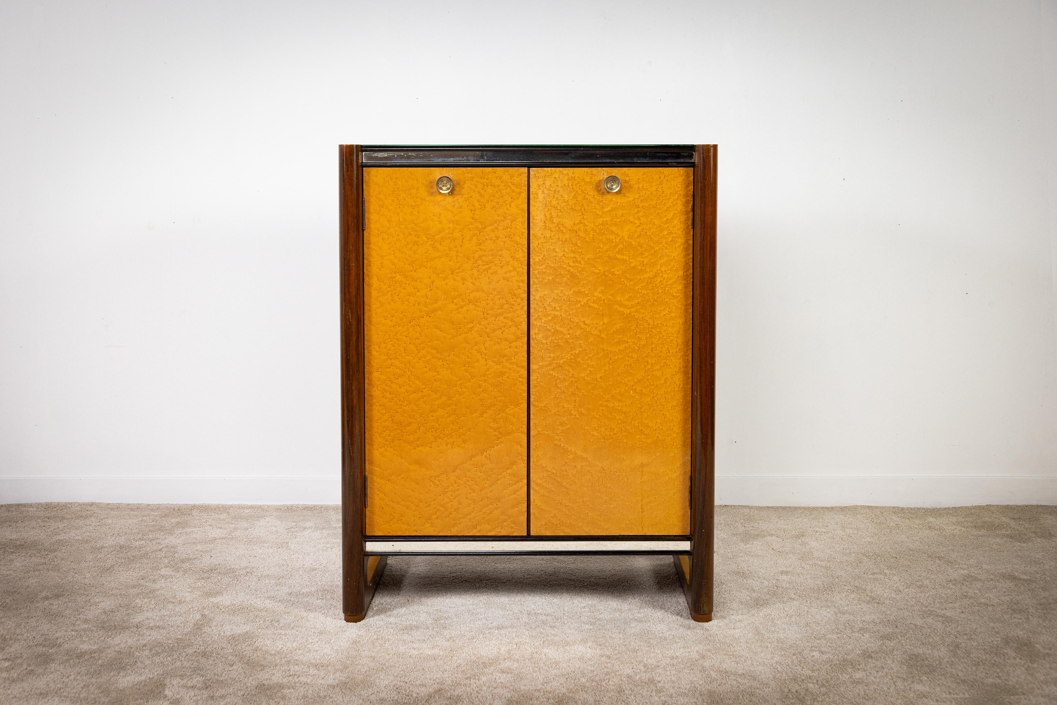 Este mueble bar de fabricación italiana de los años 30, del estilo de Gaetano y Osvaldo Borsani, se distingue por sus líneas limpias y racionales, expresión de un diseño sobrio y funcional típico de la época. Fabricados en madera y madera de brezo,