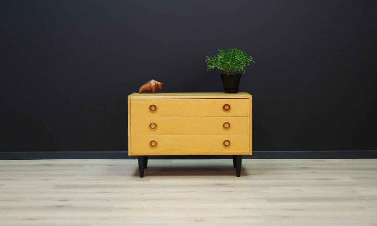 A remarkable chest of drawers from the 1960s, Scandinavian design, simple form finished with ash veneer, has three drawers. Vintage furniture preserved in good condition. Product might show slight traces of use (small scratches are visible, filled
