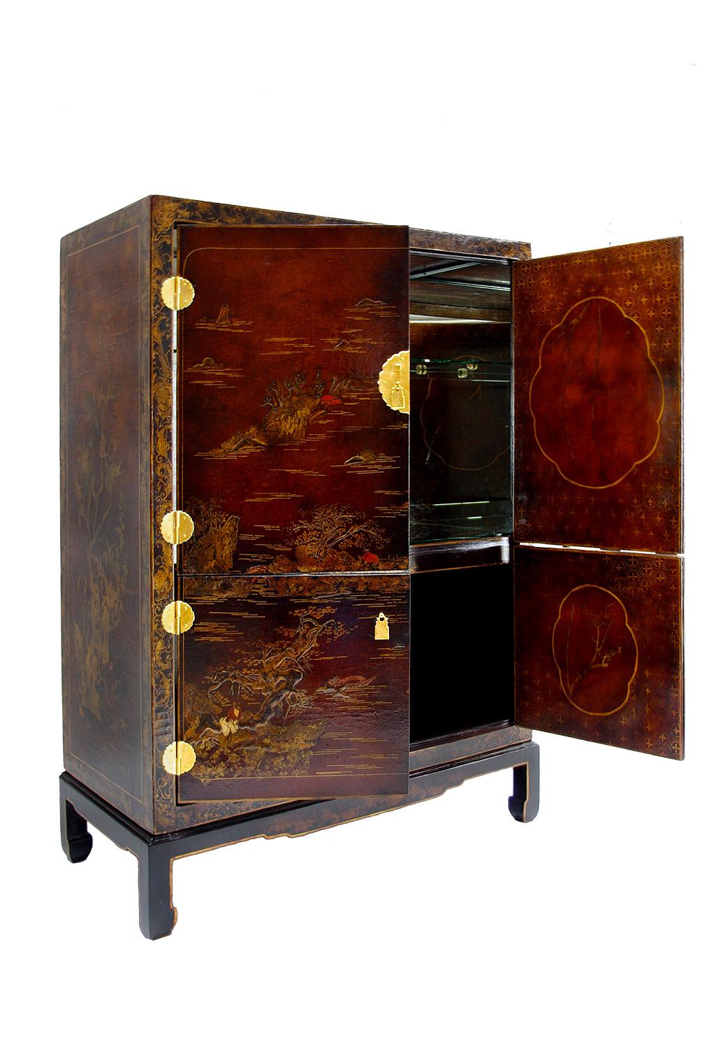 Cabinet-bar in Chinese style lacquer standing on four Chinese style square shape legs and opening by four front door leaves. They opened on a top compartment with a mirror interior and a transparent glass shelf and a lower compartment in brown