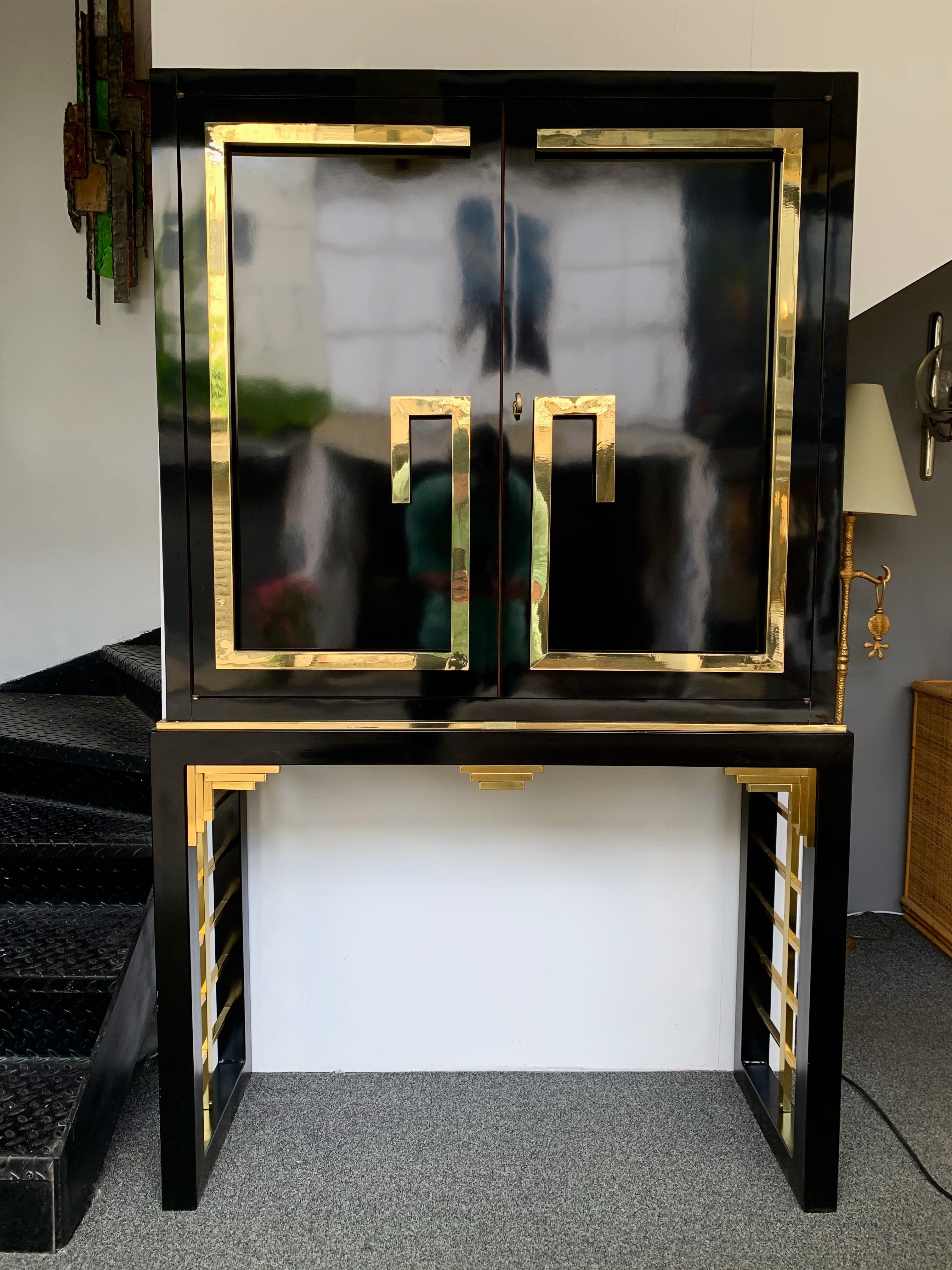 Cabinet or bar black lacquered wood with brass decor. Mirror interior. Metal feet.