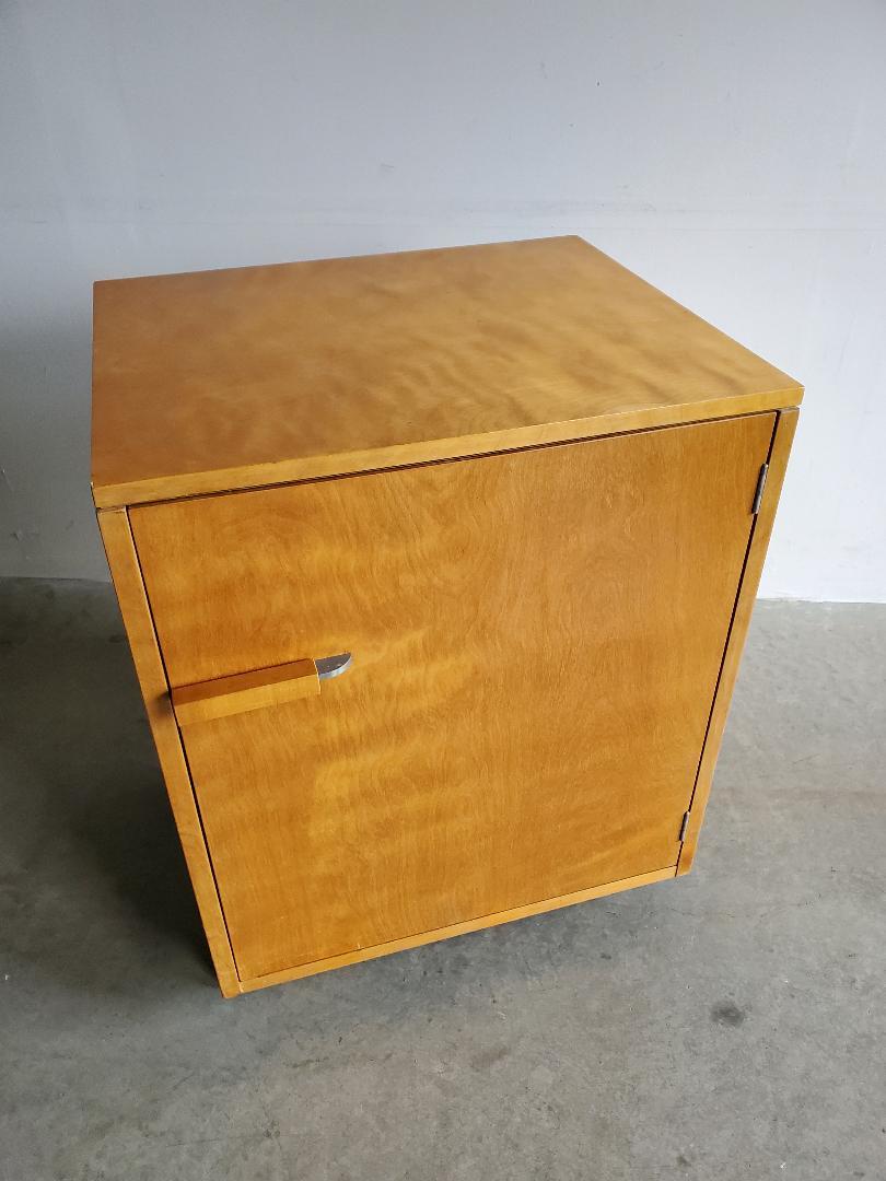 Small one door cabinet with single interior shelf in birch, walnut and aluminum, by Finnish Architect Eliel Saarinen (1873-1950), circa 1939. Beautifully figured birch. The finish appears to be original, and has a warm amber glow. Interior shelf is
