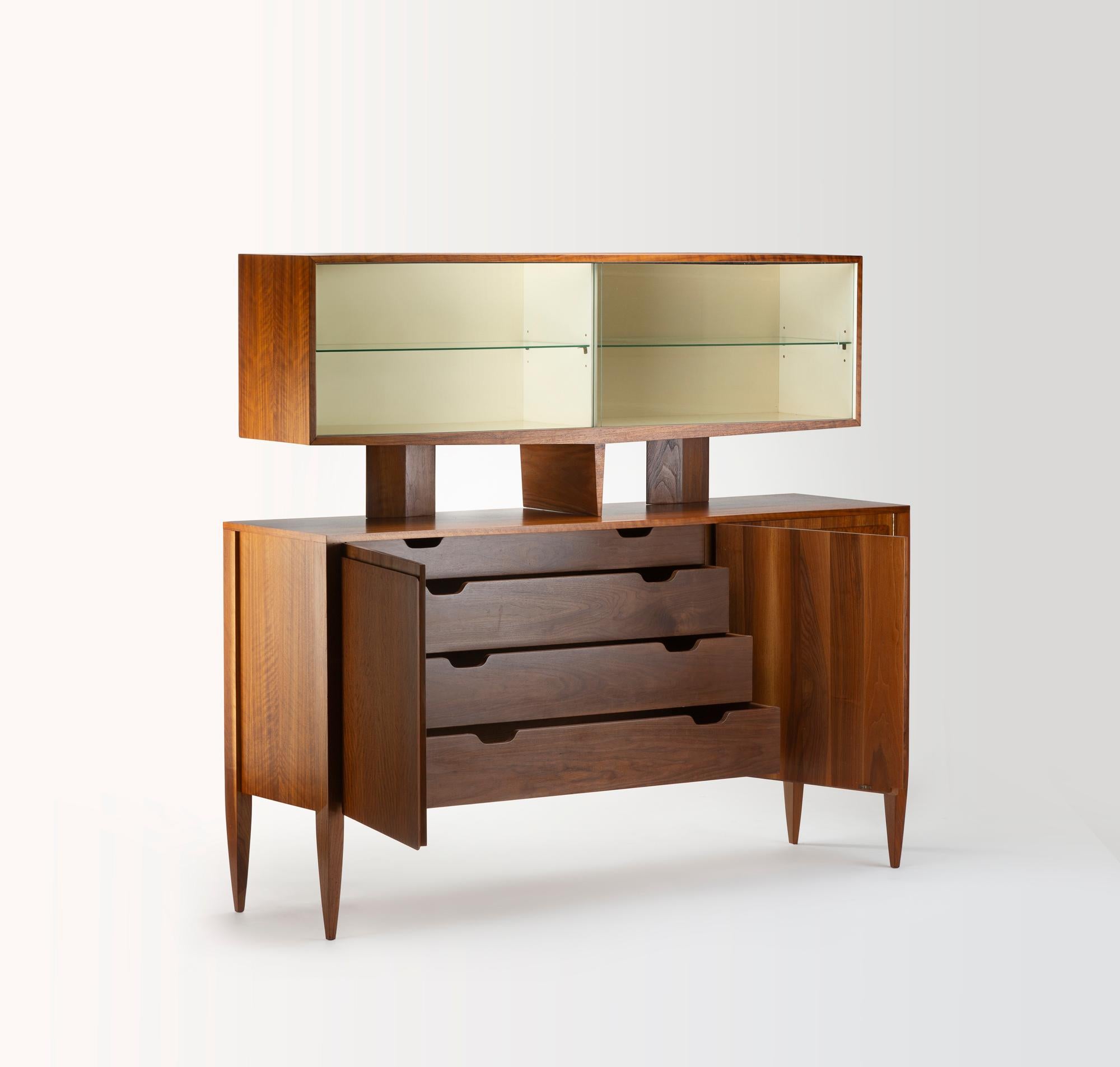 Questo mobile di Gio Ponti, creato per Singer & Sons negli anni '50, incarna la ricerca di un mobile che sia allo stesso tempo funzionale ed elegante. Realizzato in legno pregiato, presenta una cassa bassa con tre cassetti centrali e due ante
