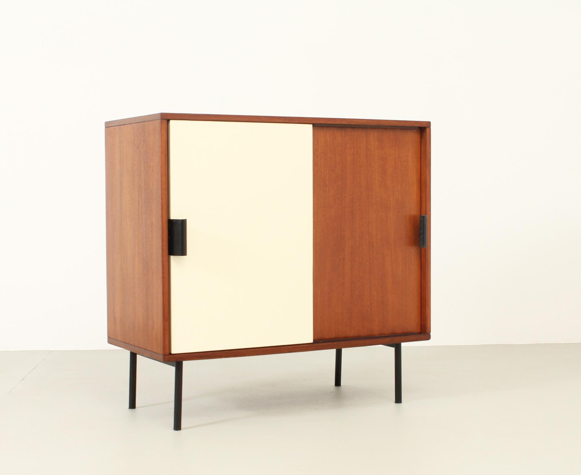 Cabinet designed in 1950's by the Italian architect Leonardo Fiori and produced by Isa Bergamo, Italy. Teak and lacquered wood and black enamelled metal with sliding doors. Signed with Isa logo.